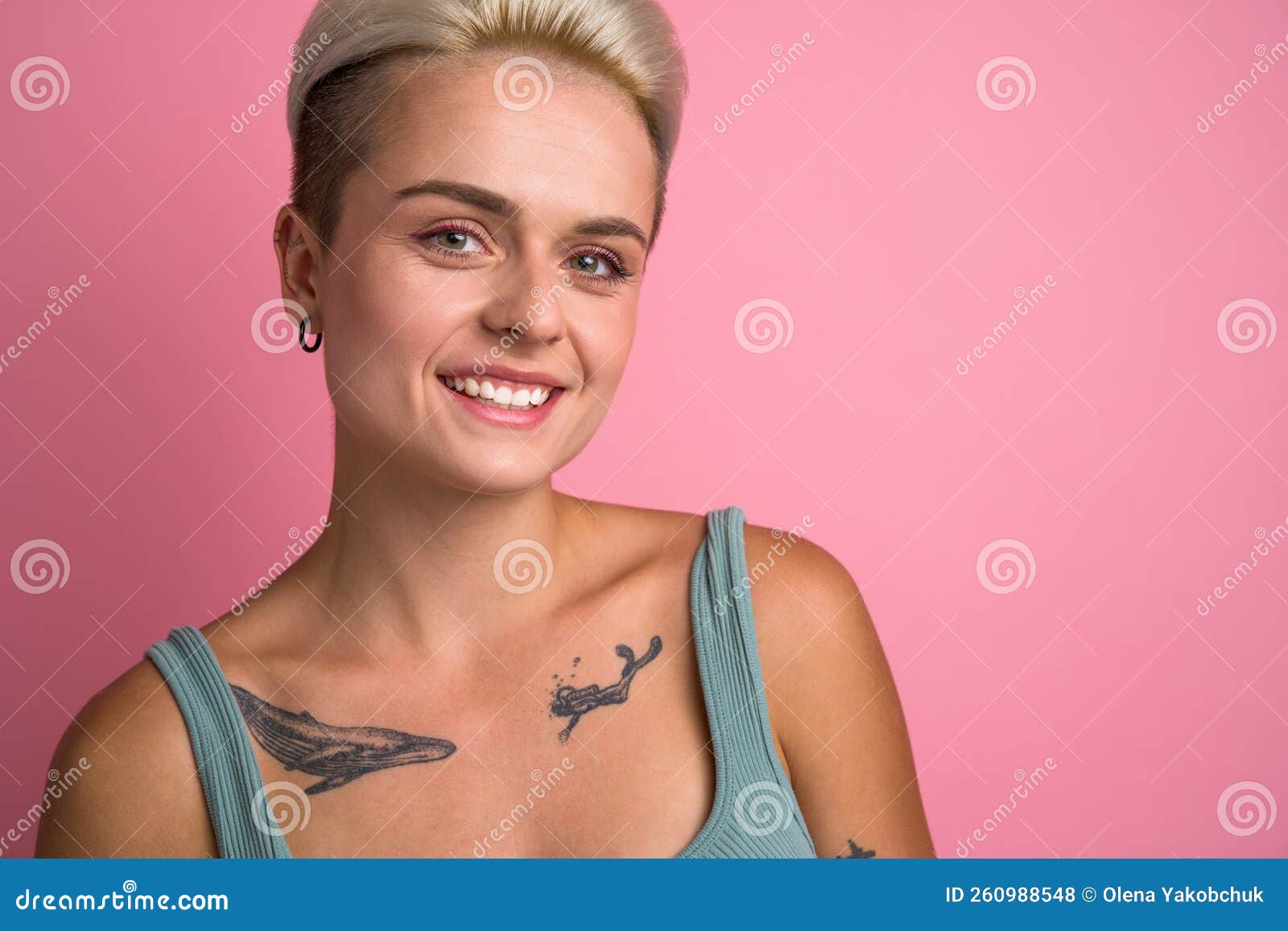 Short Haired Blonde Woman with Tattoos Looking Straight To the Camera