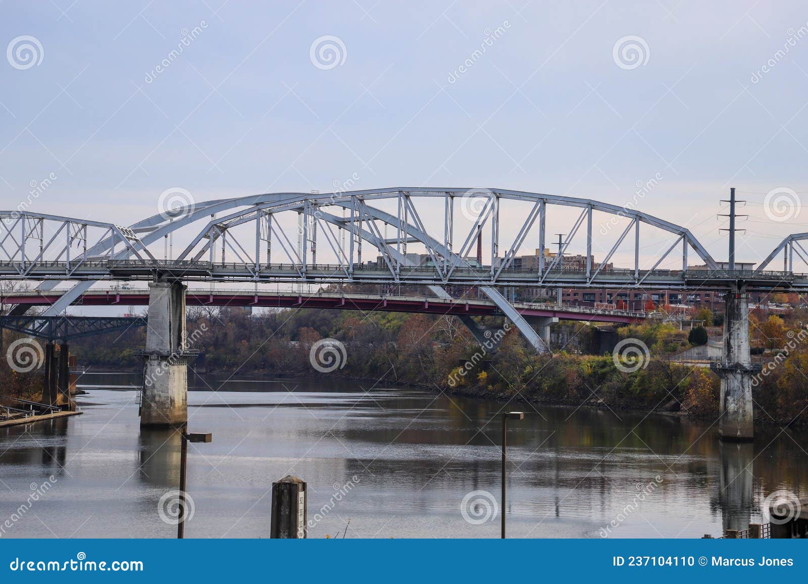 a shot of cumberland river with the john seigenthaler pedestrian bridge over the water surrounded by gorgeous autumn trees