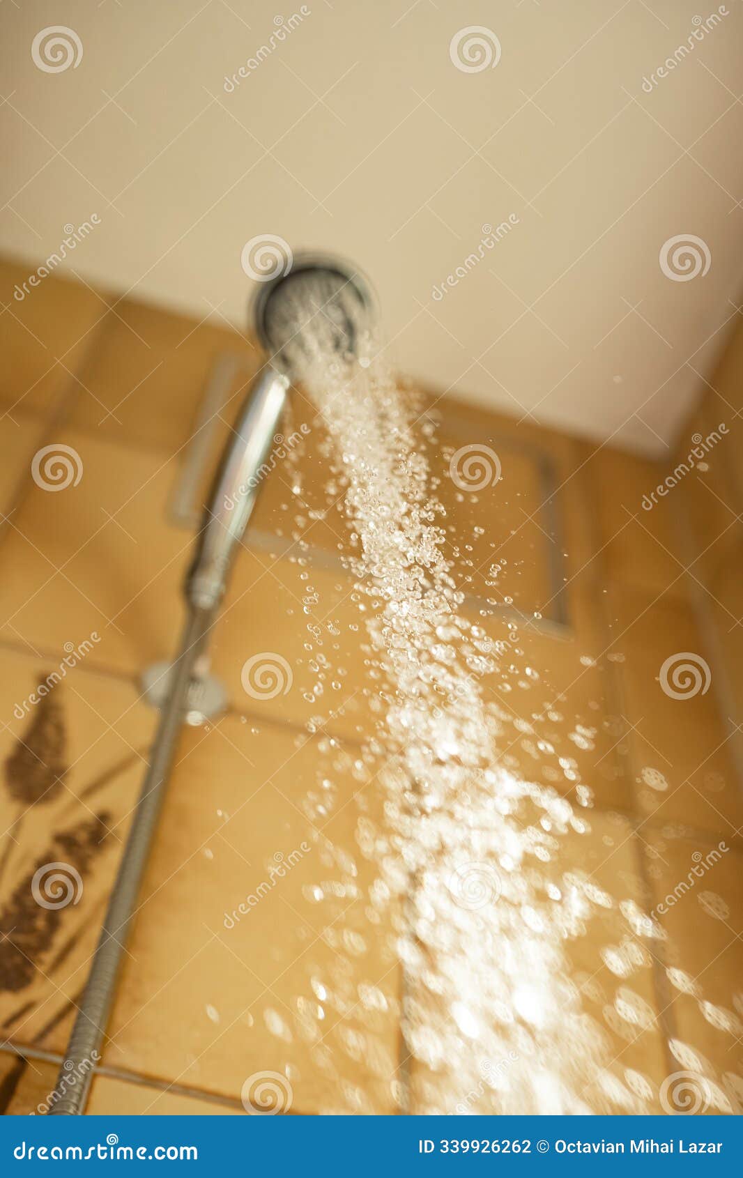 shower head with running water. high shutter speed capture of water stream, water droplets, shallow depth of field, low angle, no