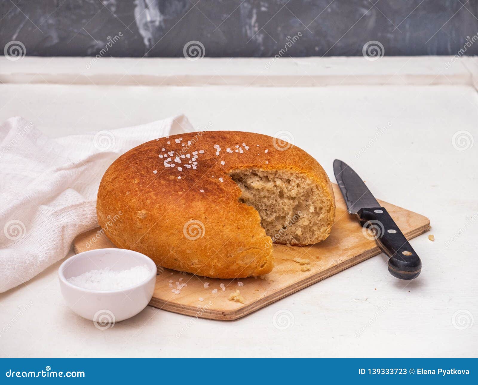 Shown is a Section of Round Homemade Freshly Baked Bread. Salt Shaker
