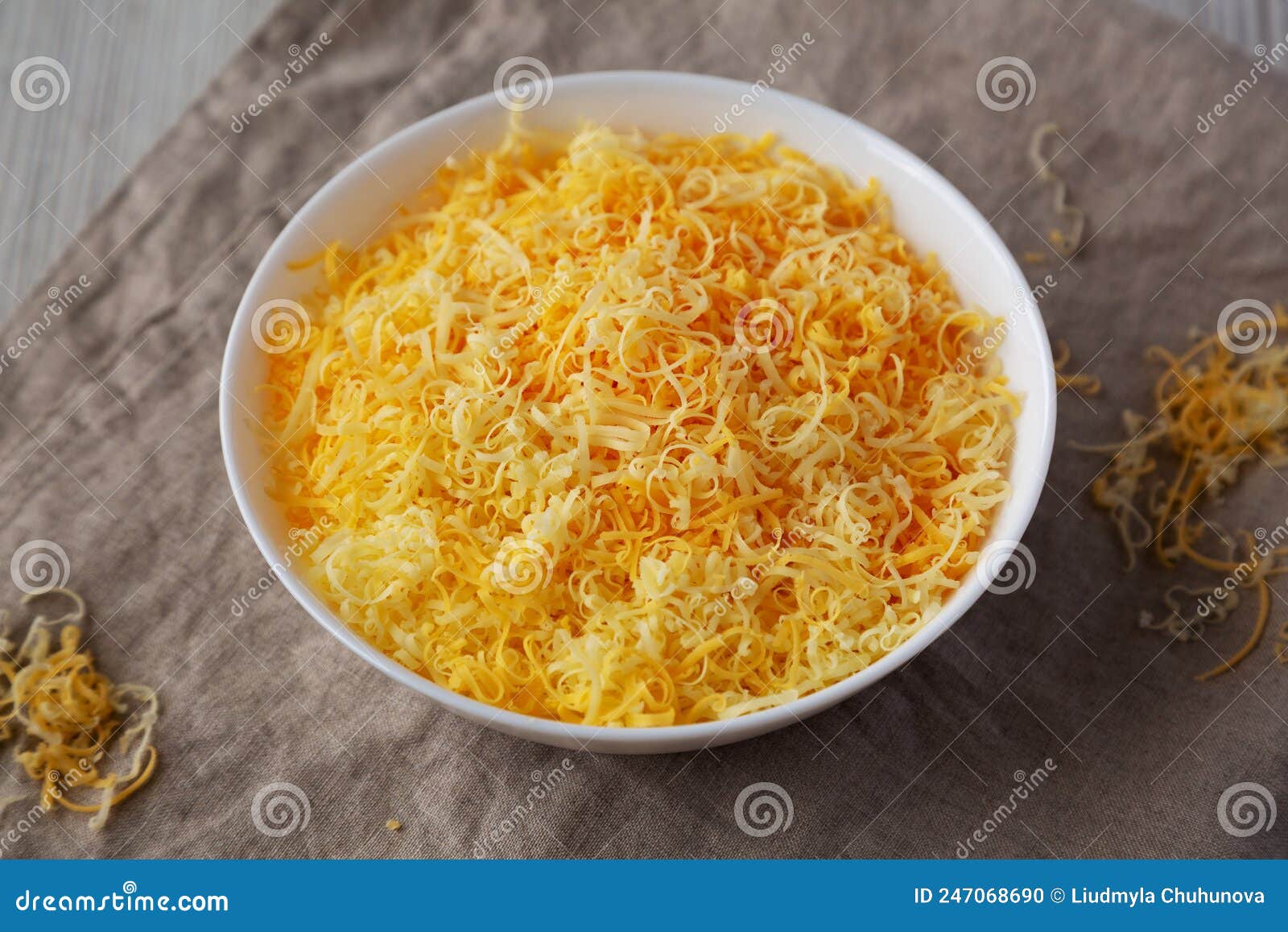 Shredded Mexican Cheese Mix in a White Bowl, Side View Stock Photo