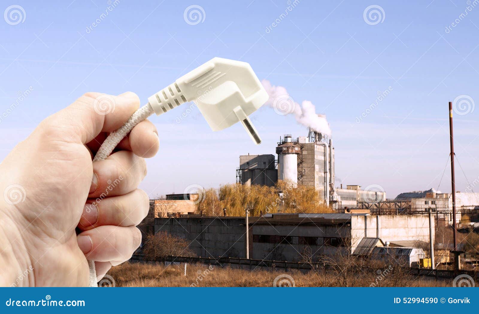 Shtepsel in hands on background of industrial subjects. Shtepsel in hands on background of industrial plant