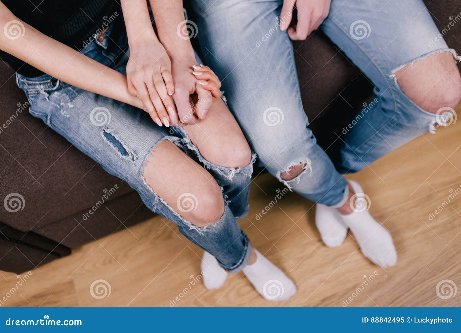 Shy Lovers Sitting Together on Brown Bed Stock Image