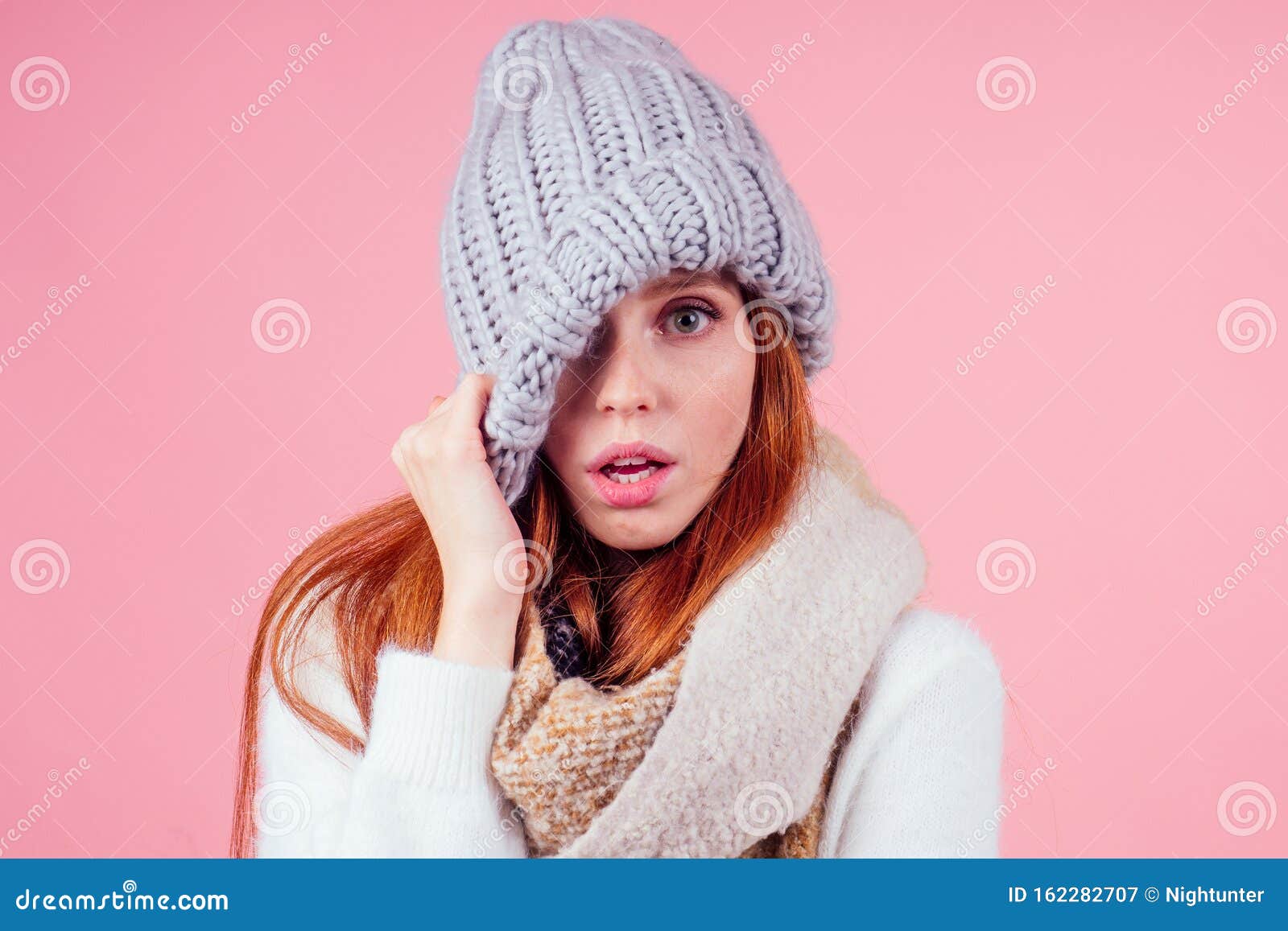 Shy Redhead Ginger Woman Putting A Knitted Spiky Hat On His Head Hiding Eye And Open Mouth In