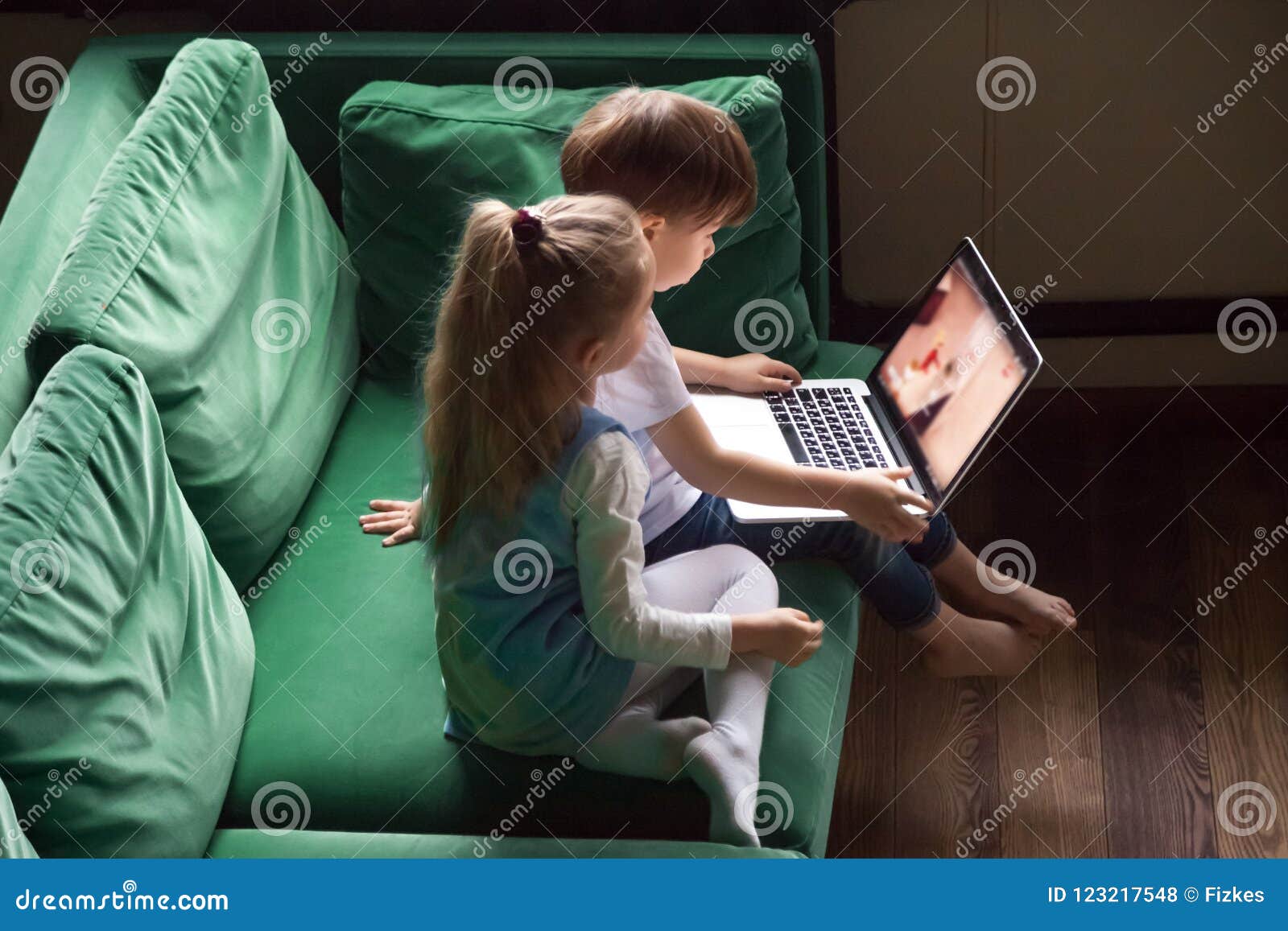 siblings boy and girl watching kid cartoons using laptop togethe