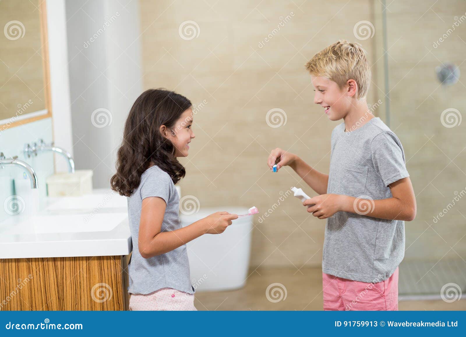 Siblings Interacting with Each Other while Brushing Teeth Stock Image