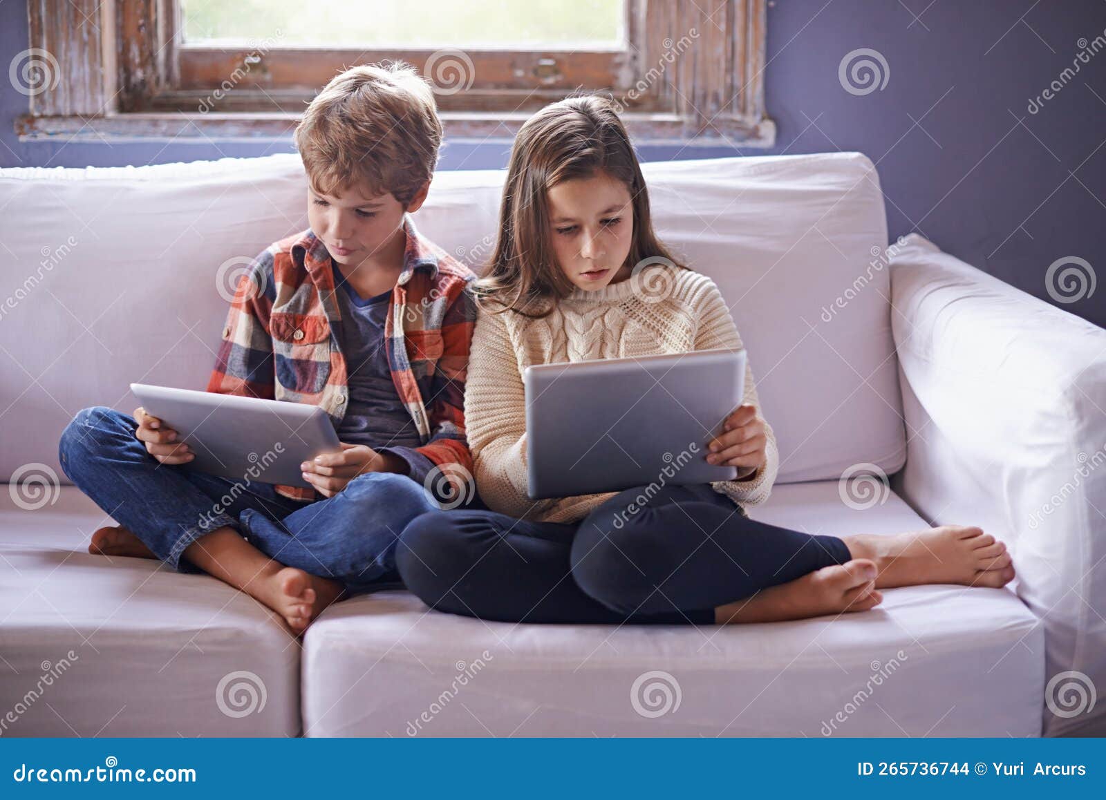 Siblings Online. a Young Brother and Sister Using Their Digital Tablets