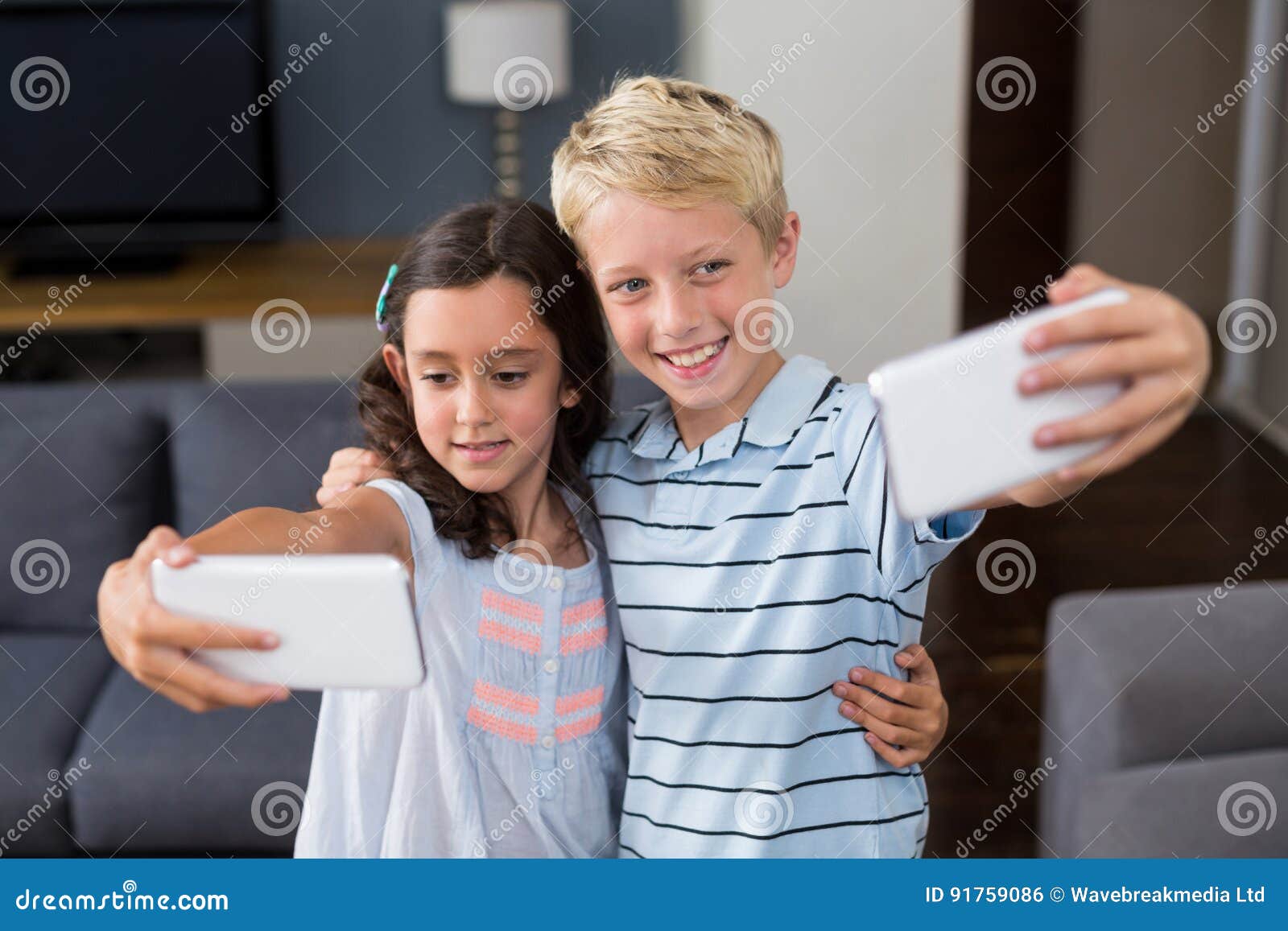 Siblings Taking Selfie on Their Mobile Phone in Living Room Stock Photo ...