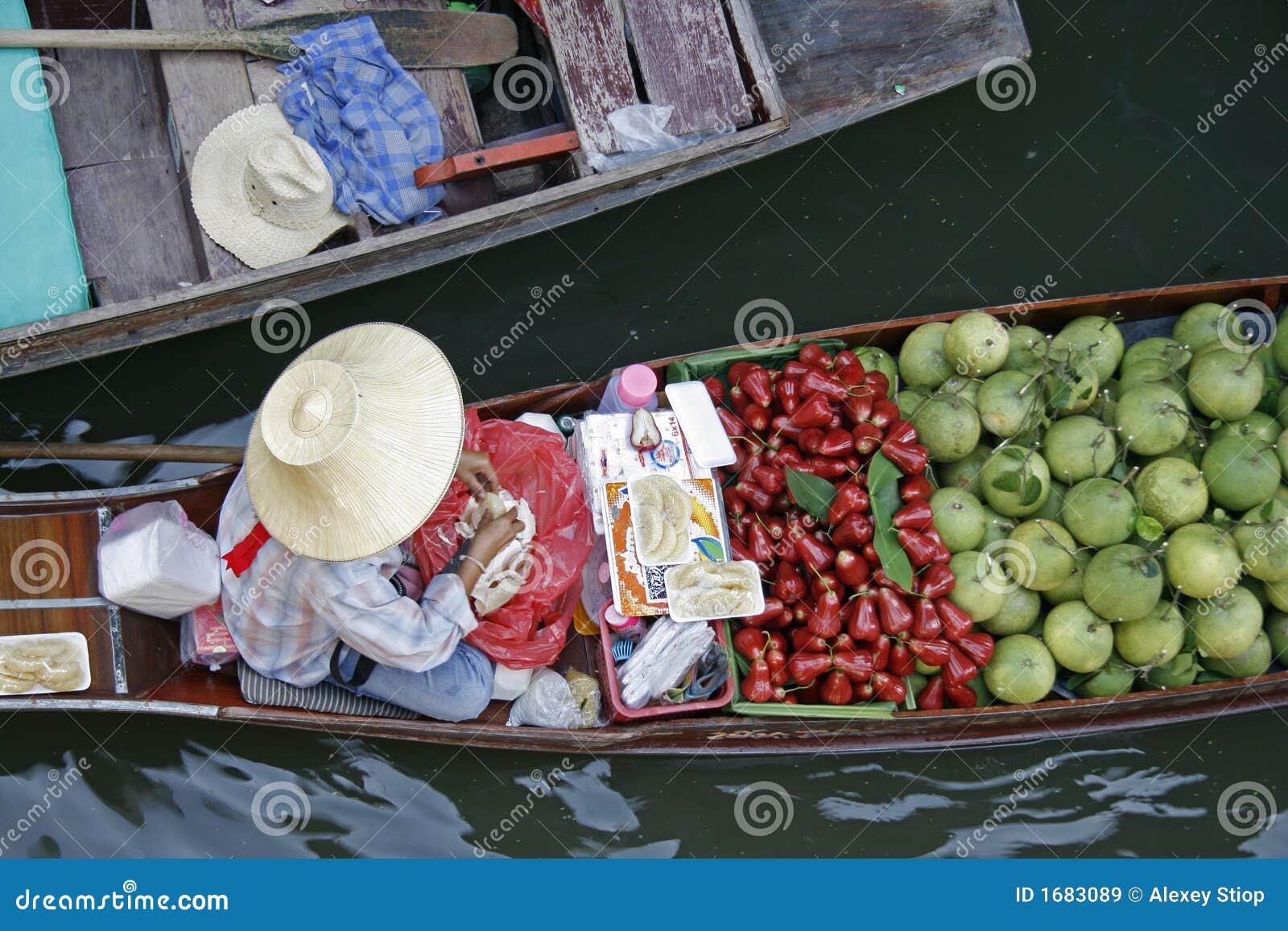 Sich hin- und herbewegender Markt 1. Ein Fruchtverkäufer in einem Boot an sich hin- und herbewegendem Markt nahe Bangkok, Thailand