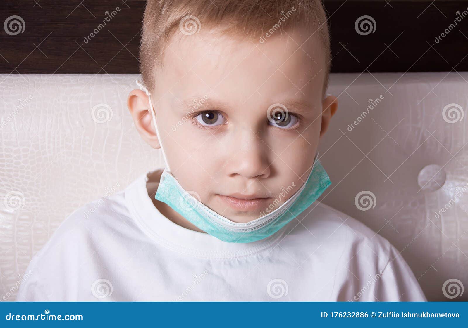 sick boy sitting in bed in medical mask and doesn t feel well