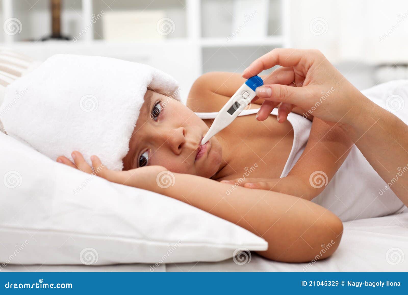 sick child with fever laying in bed