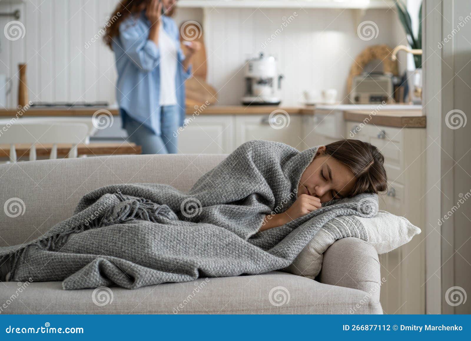 sick repressed teen girl sleeping in house on couch wrapped in blanket warming up in cold weather