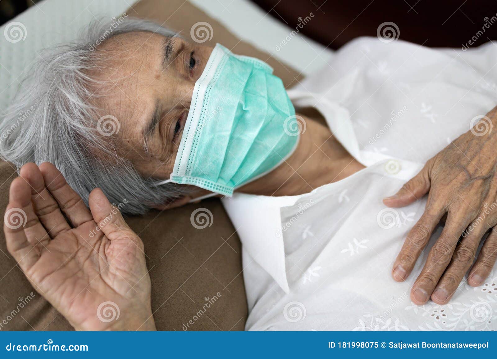 sick senior woman wear a mask lying in uncomfortable bed,unwell,exhausted old people have a fever,cold and flu,tired elderly