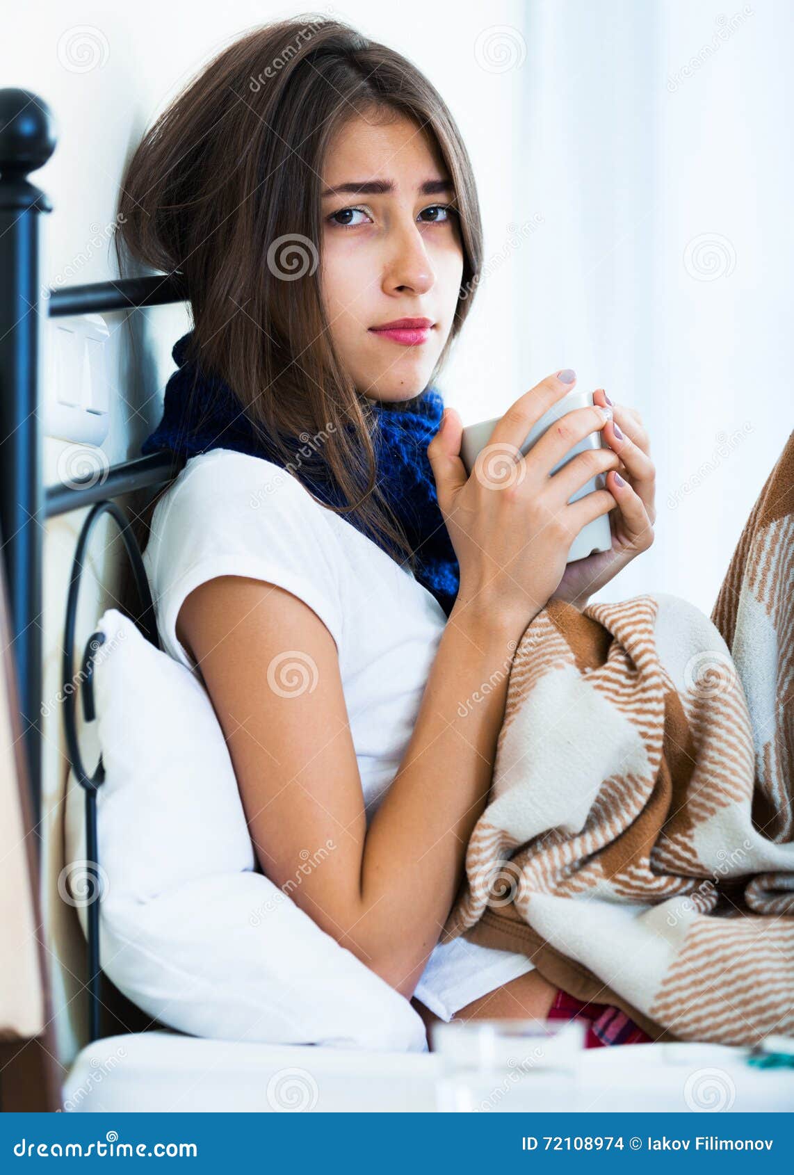 Sick Teenage Girl With Hot Tea And Medication Indoors