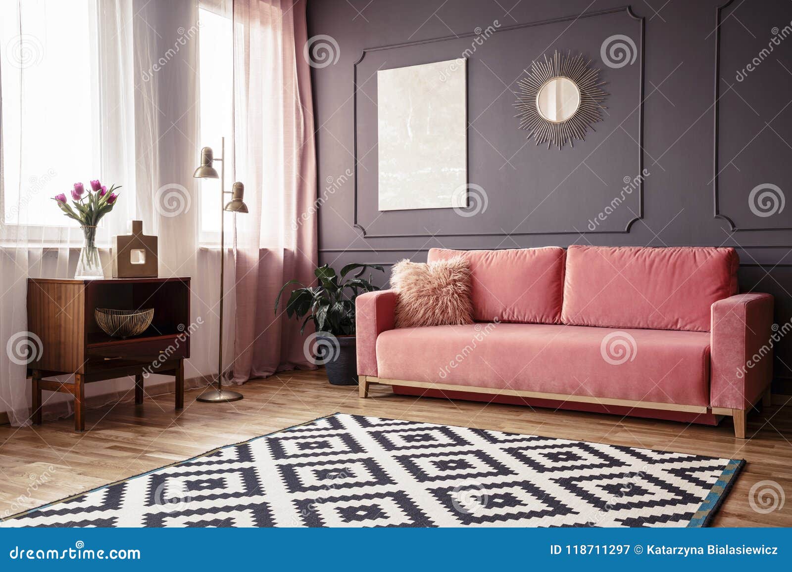 side angle of a living room interior with a powder pink sofa, pa