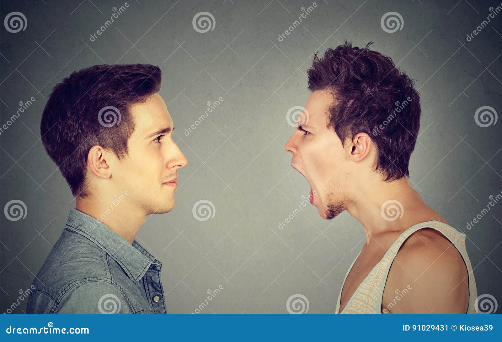 side profile portrait of young angry man screaming at a calm smiling guy