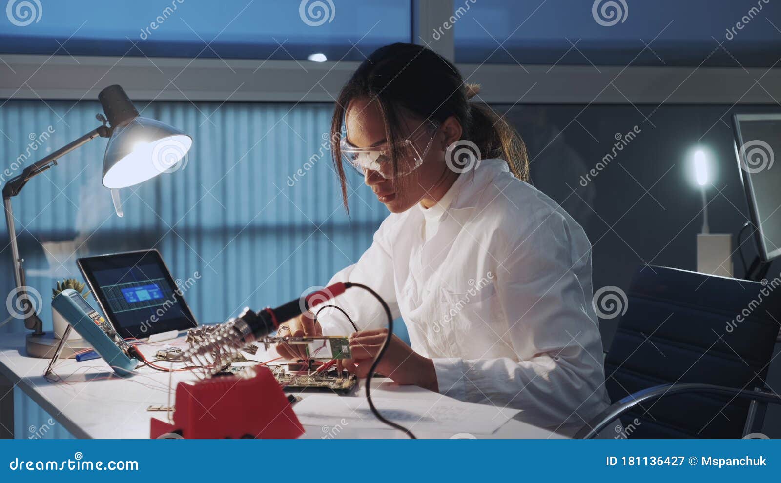 Side View of African American Electronics Specialist Working with Multimeter Tester and Other