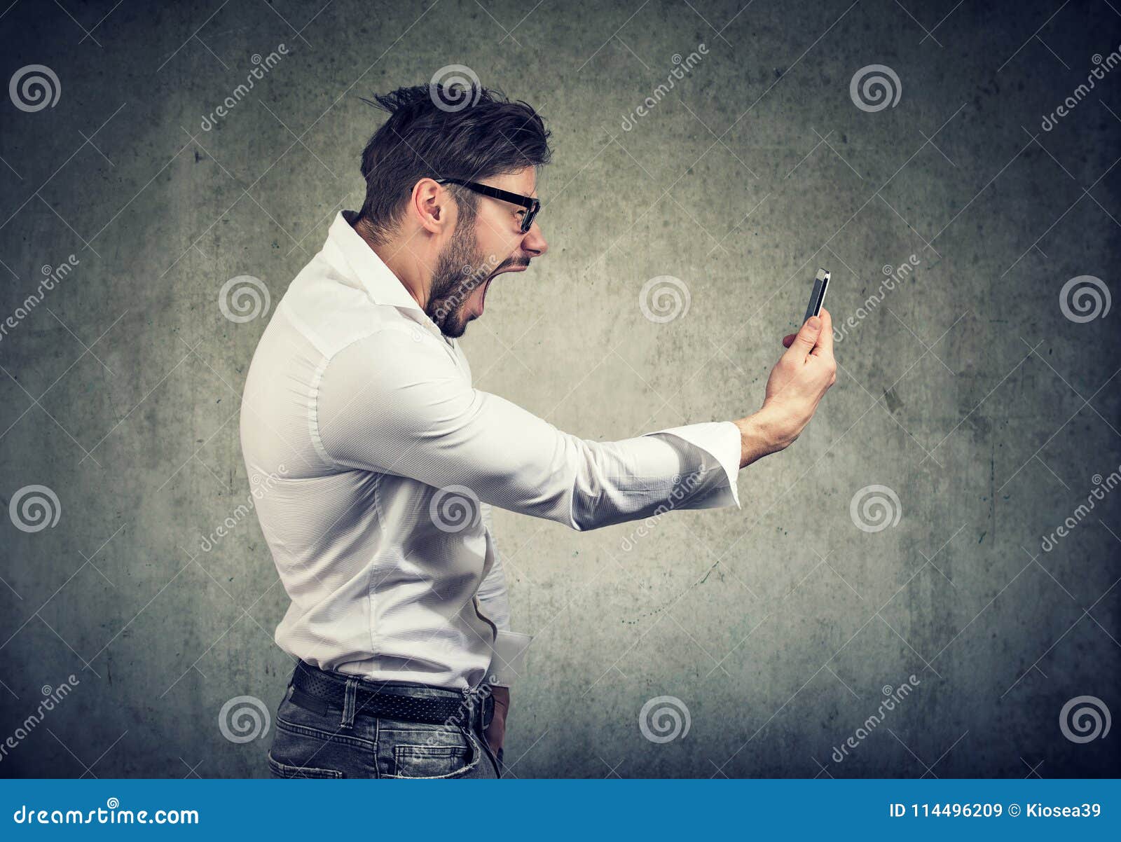 angry man holding smartphone and shouting in anger