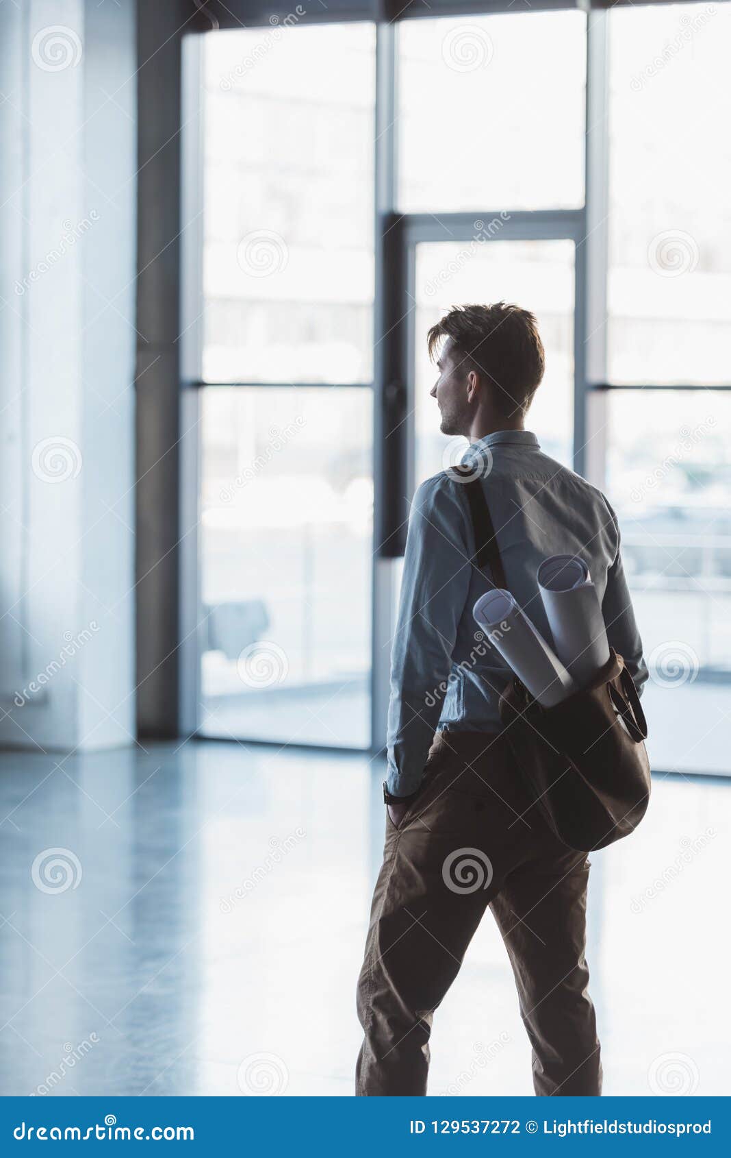 Side View of Architect with Blueprints in Bag Standing Stock Photo