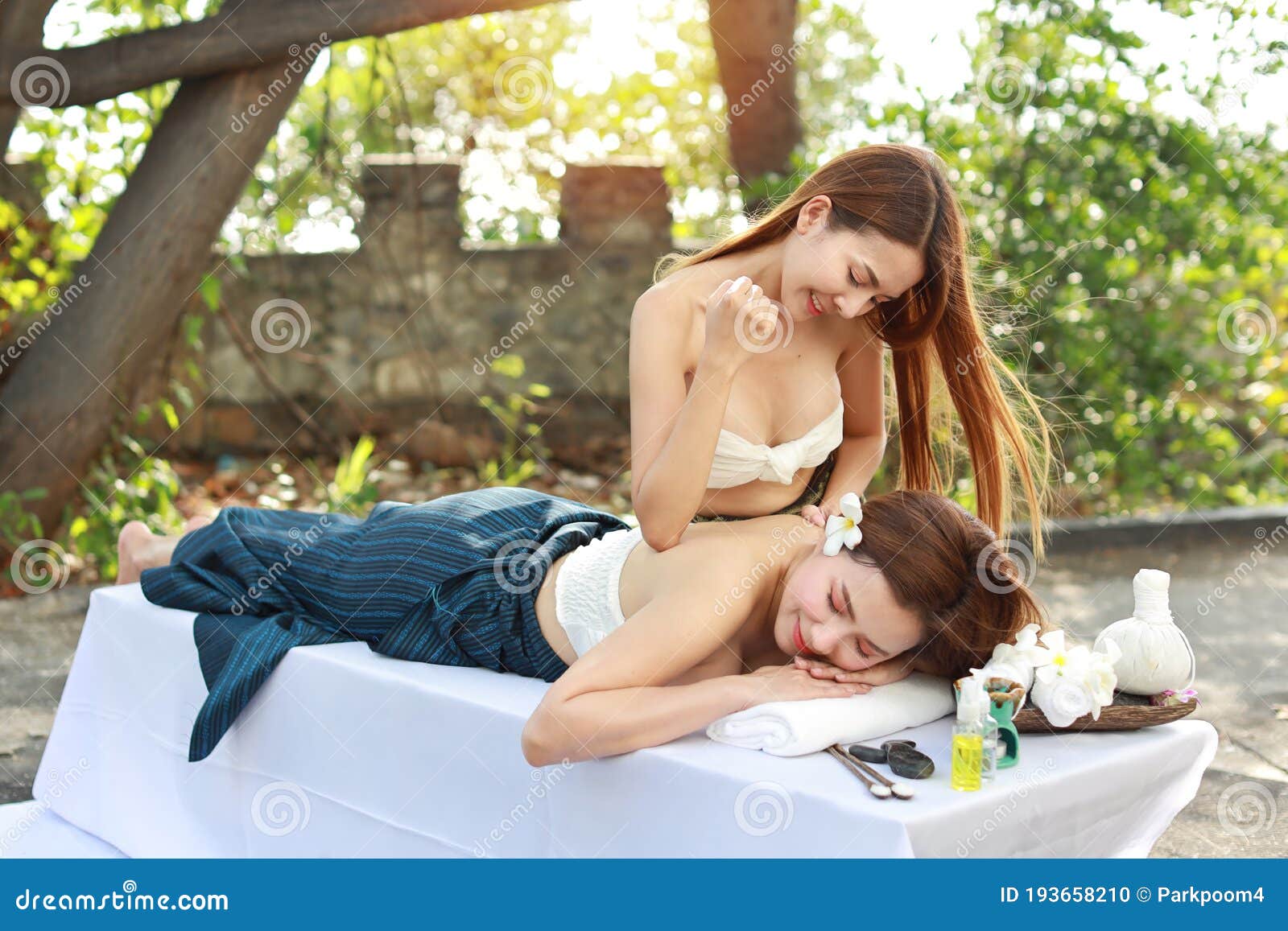 Side View 2 Beautiful and Asian Young Woman in White Dress Enjoying Oil Spa Massage Salon during Sunny Day with Happy Face Stock Photo photo