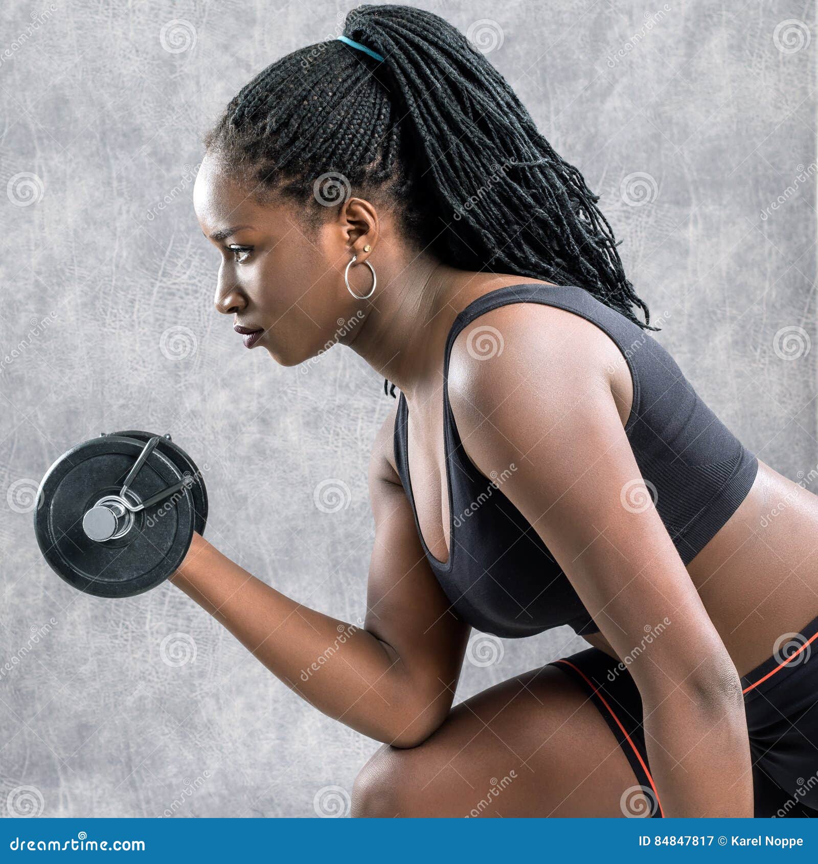 Side View Of Black Teen Girl Working Out With Dumbbell