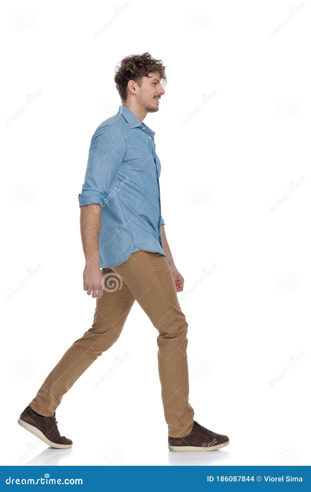 Side View of Casual Man in Denim Shirt Smiling and Walking Stock Photo ...