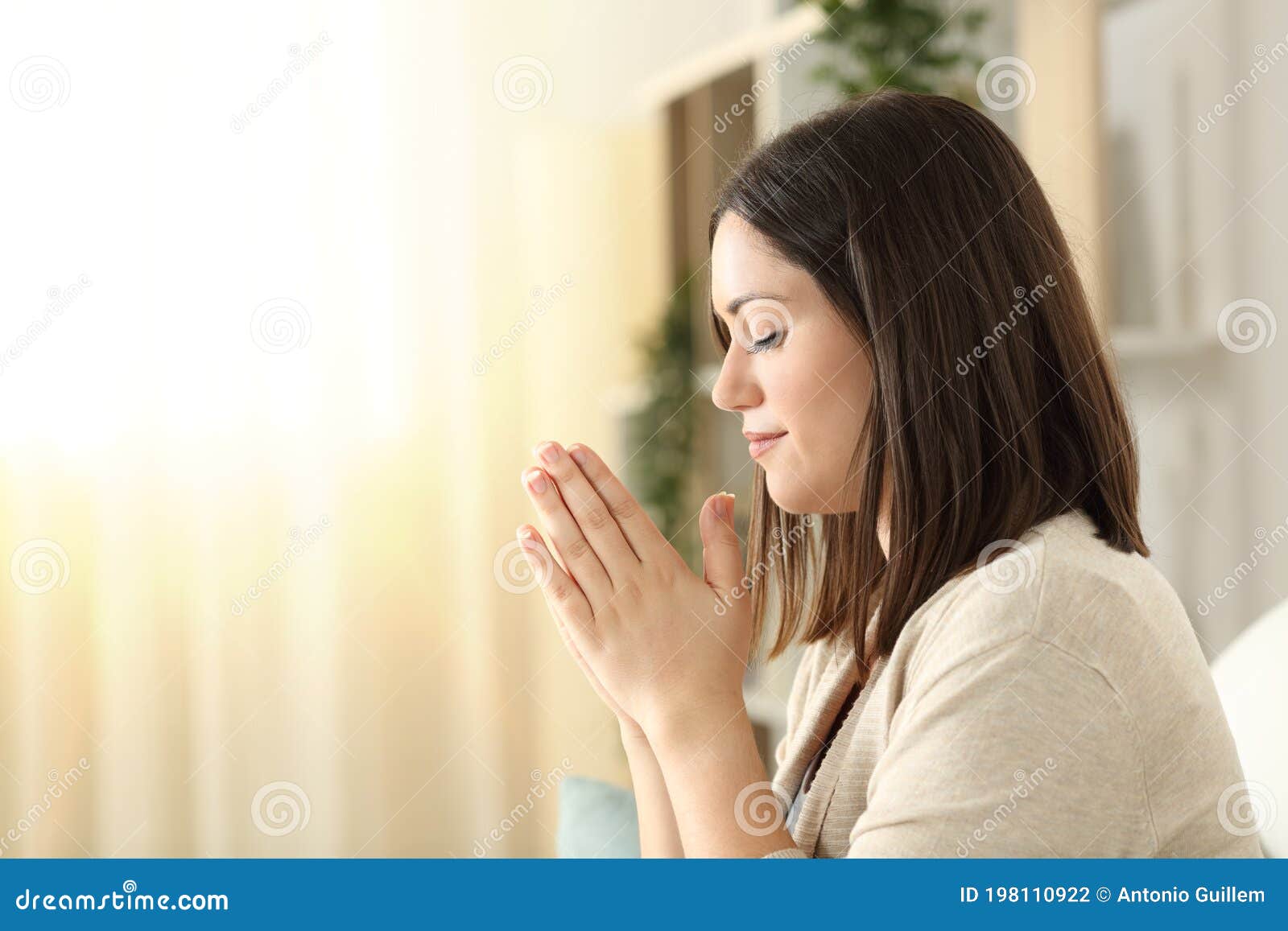 side view of a woman praying at home