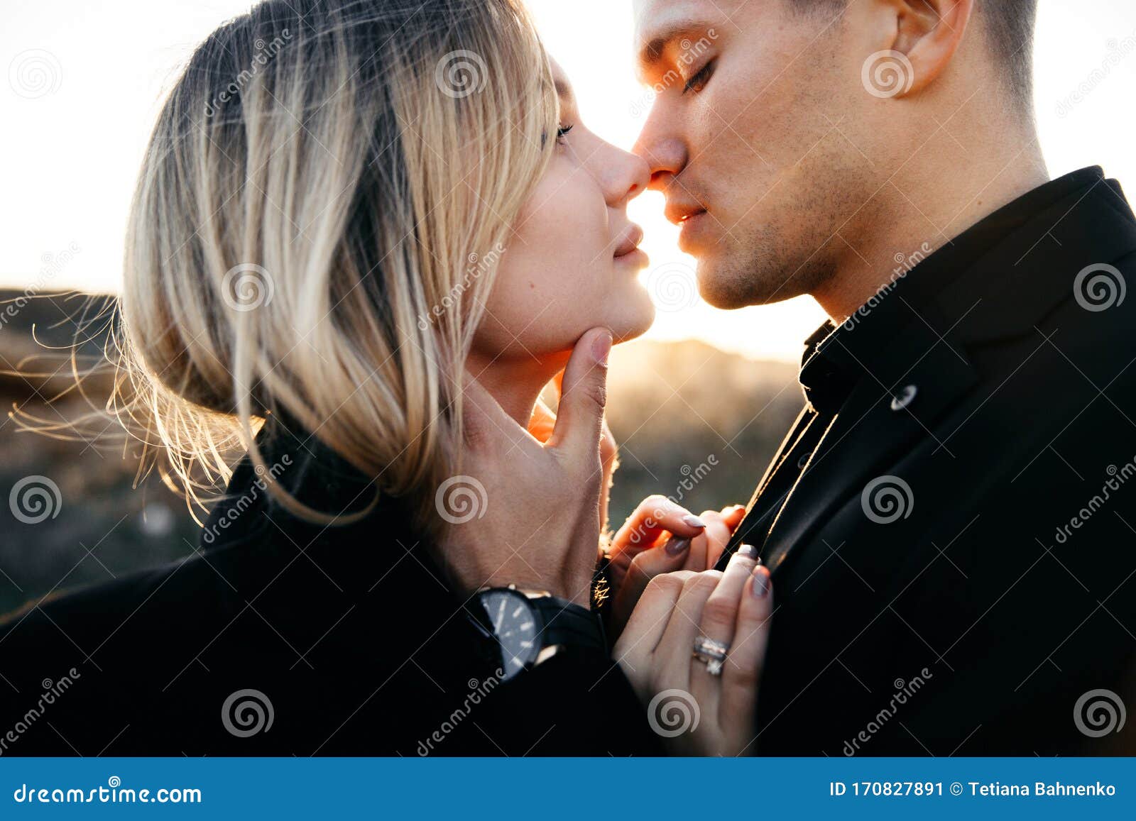 side view close up portrait of two young lovers kissing on the sunset. man gently touching his lovely girl. newlyweds in