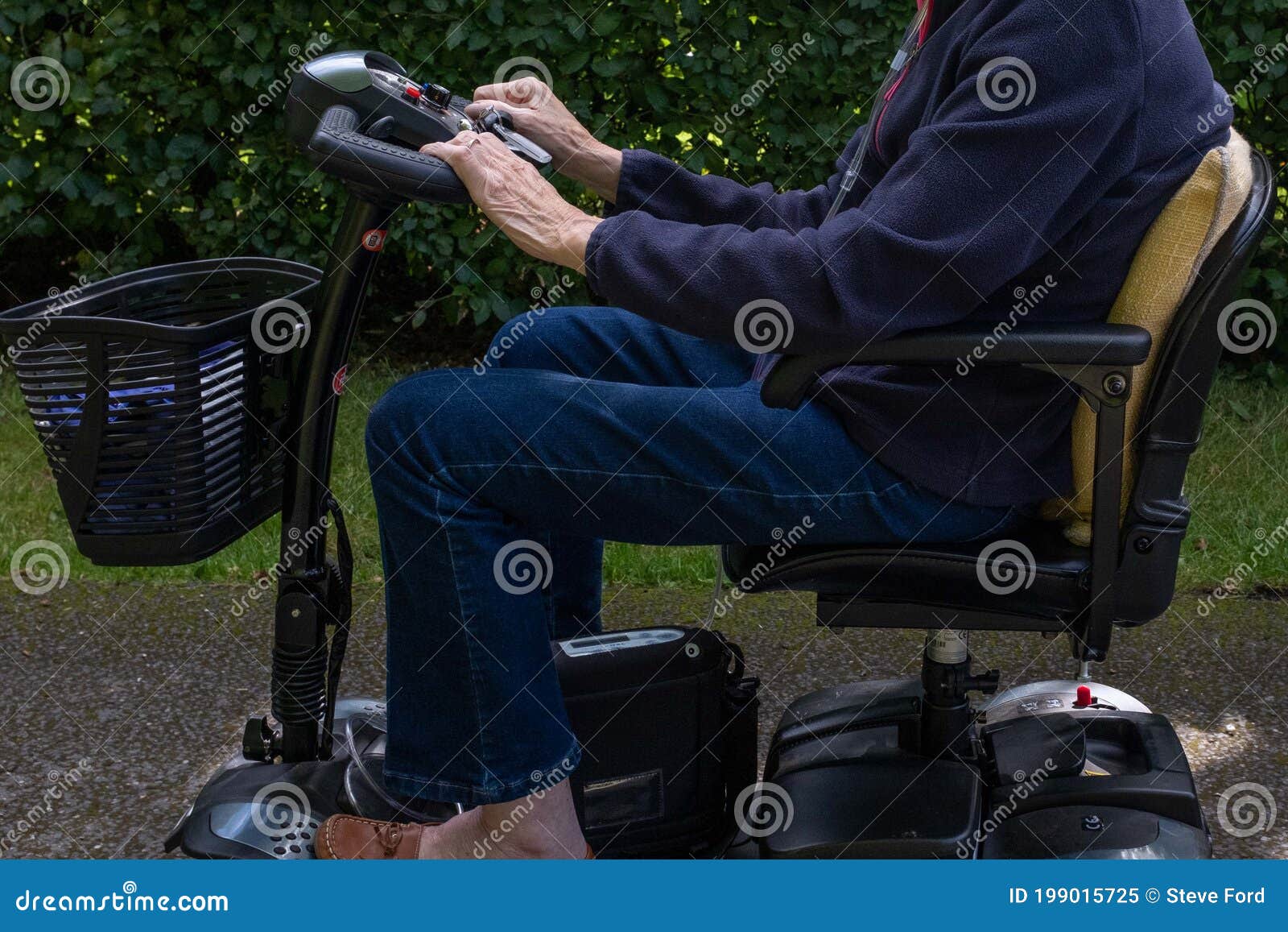 side view of elderly lady riding a mobility scooter.