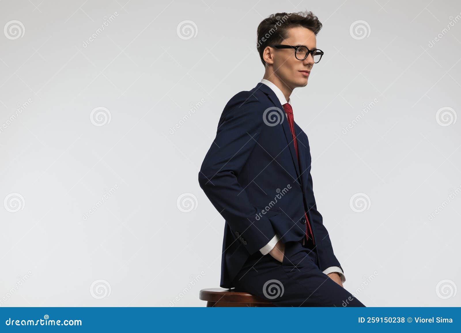 side view of elegant man with glasses holding hands in pockets