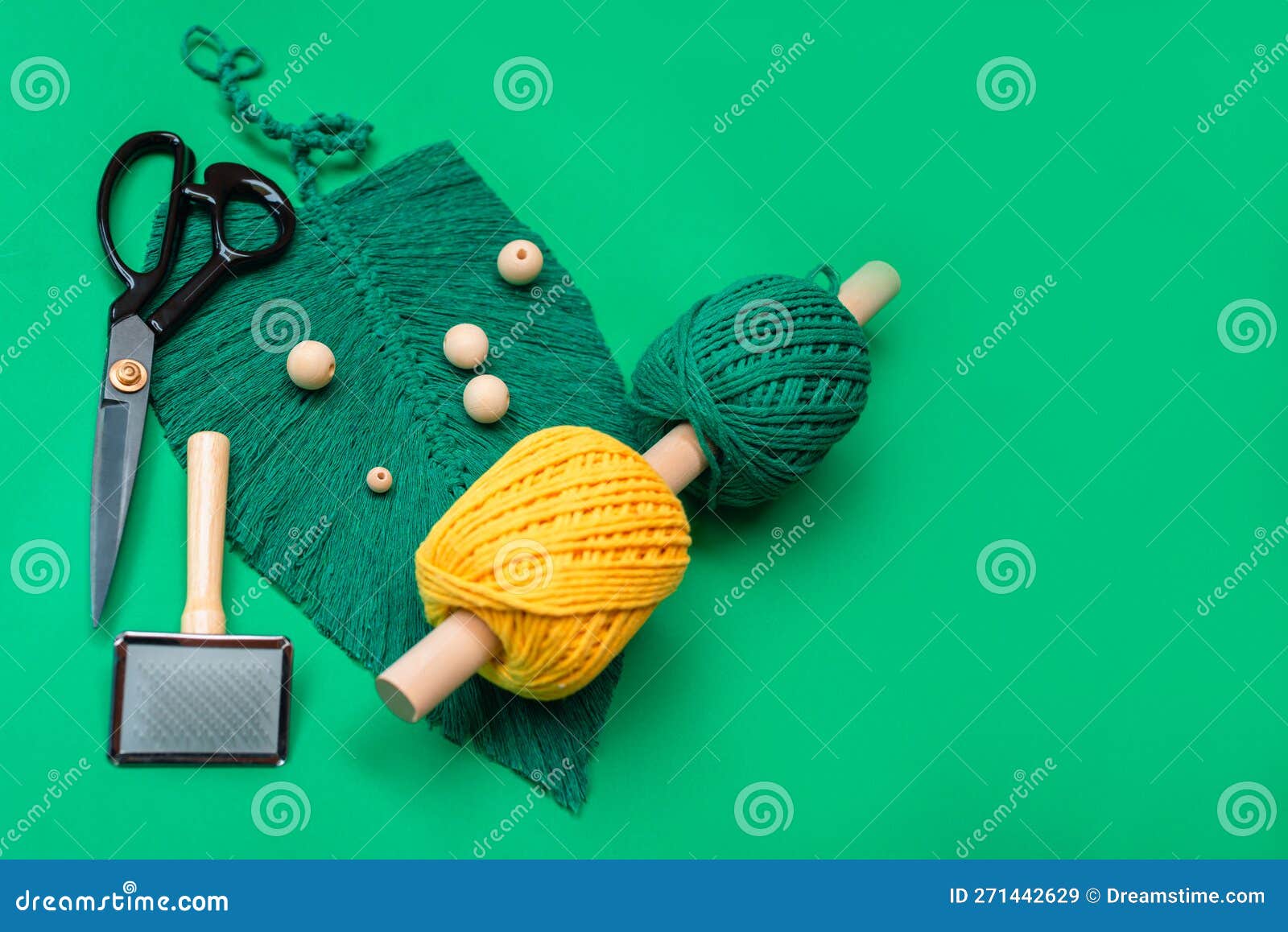 side view of green macrame leaf with macrame supplies on green background