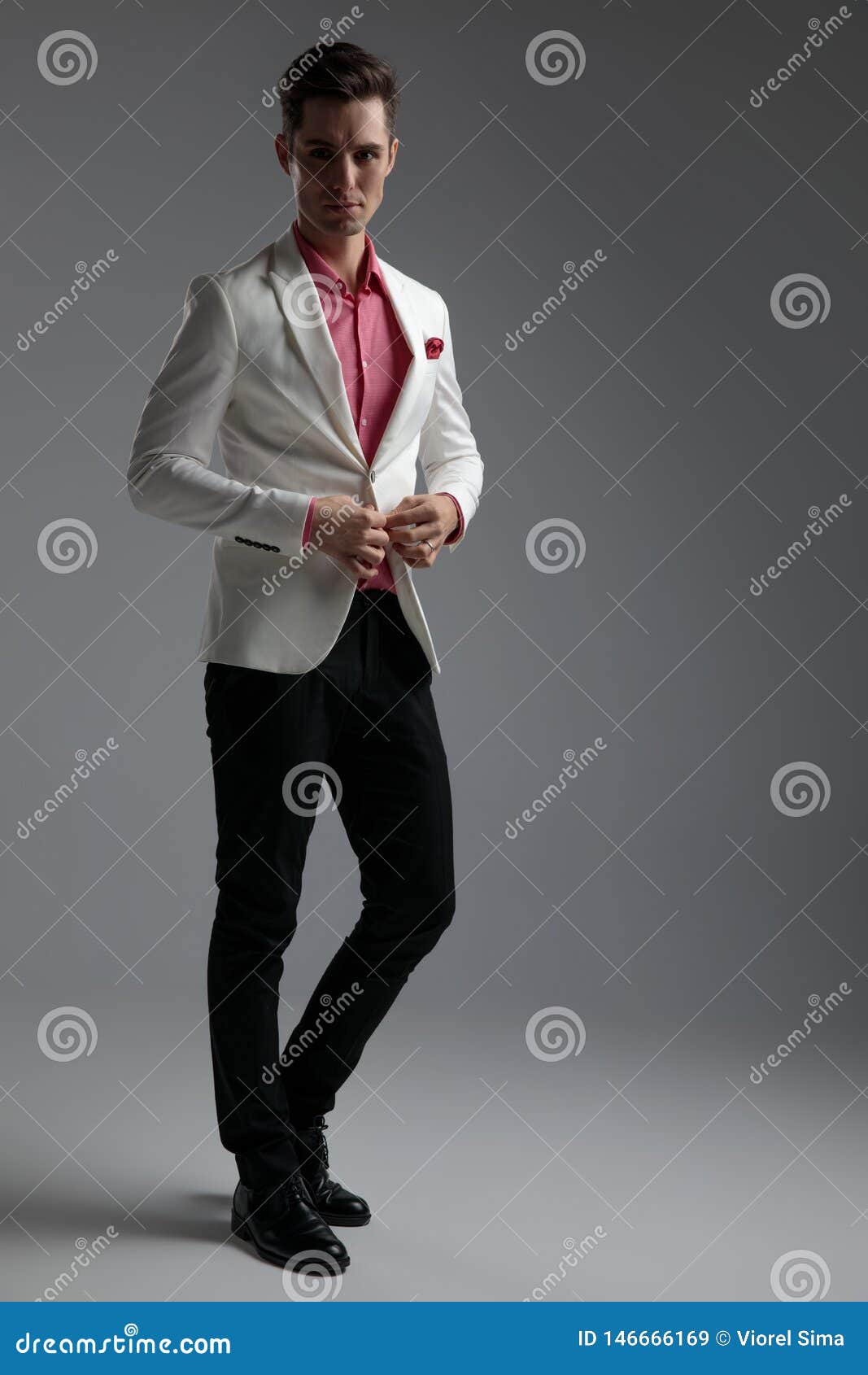 Side View of Handsome Guy Buttoning His Suit while Standing Stock Image