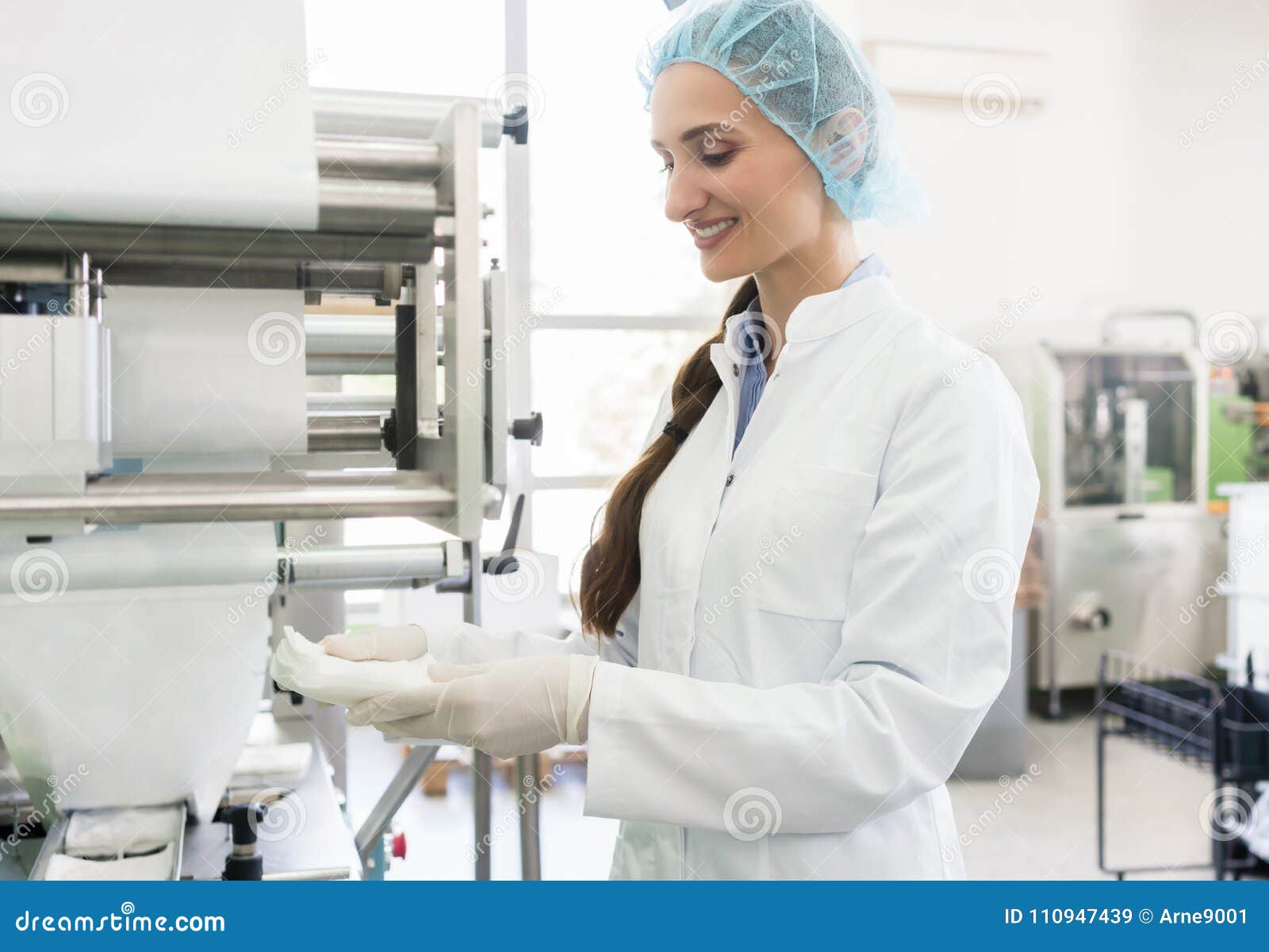 happy employee wearing lab coat while handling sterile wipes