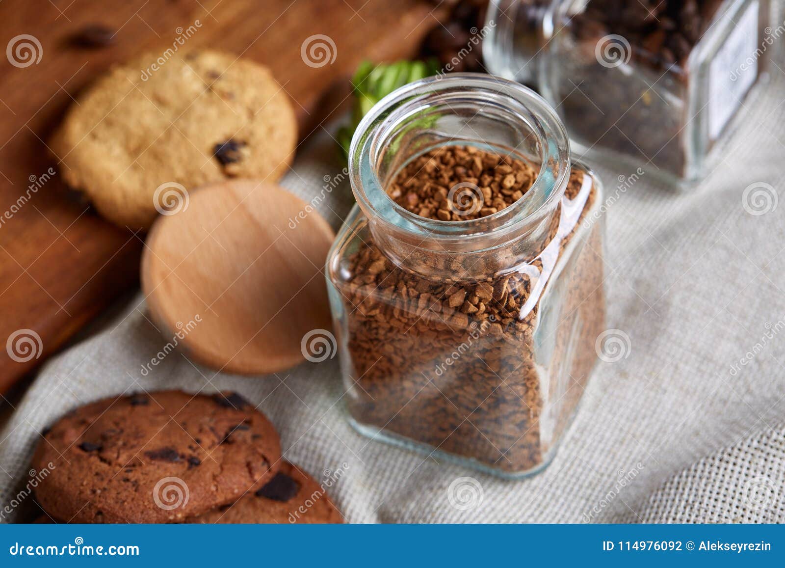 roasted coffee beans get out of overturned glass jar on homespun tablecloth, selective focus, side view