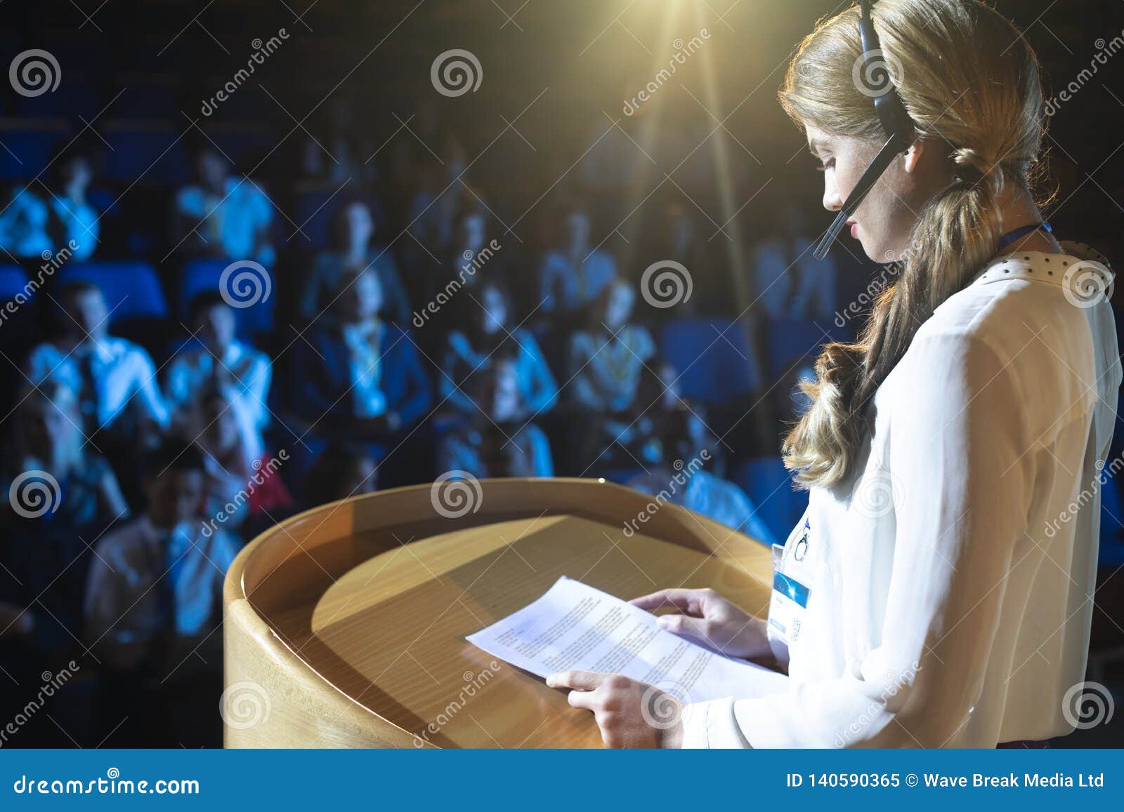 businesswoman in headset giving presentation in the auditorium