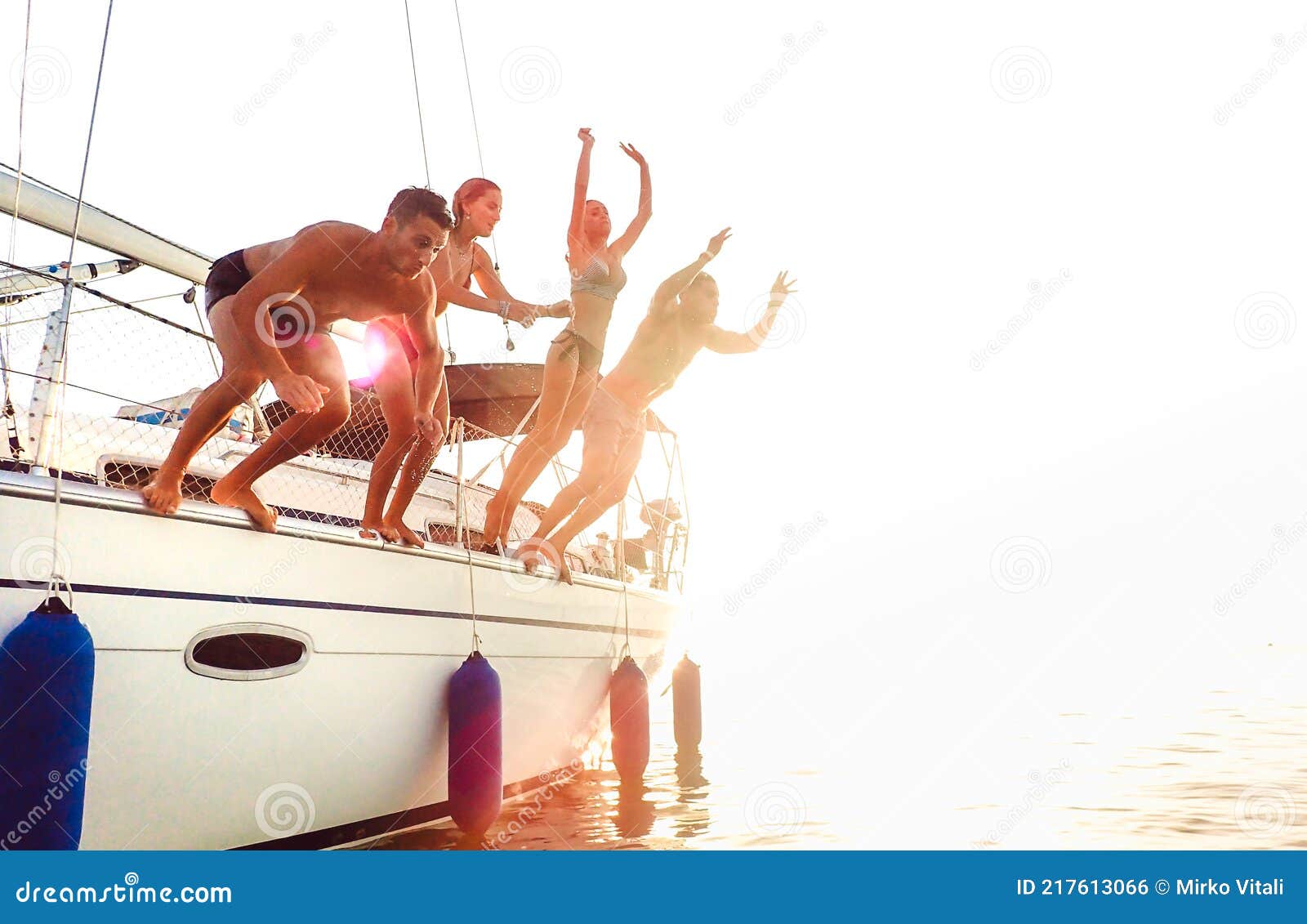 Side View of Young Crazy Friends Jumping from Sailboat on Sea ...