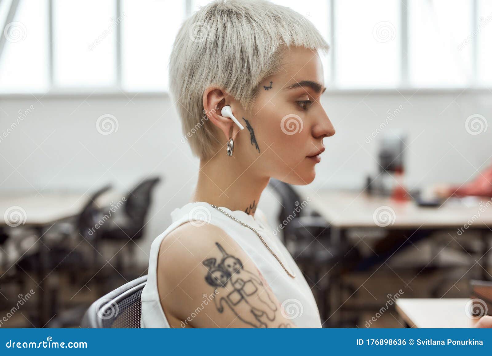 Side View of Young and Cute Blonde Tattooed Business Woman with Short  Haircut Wearing Wireless Earphones while Working Stock Photo - Image of  attractive, female: 176898636