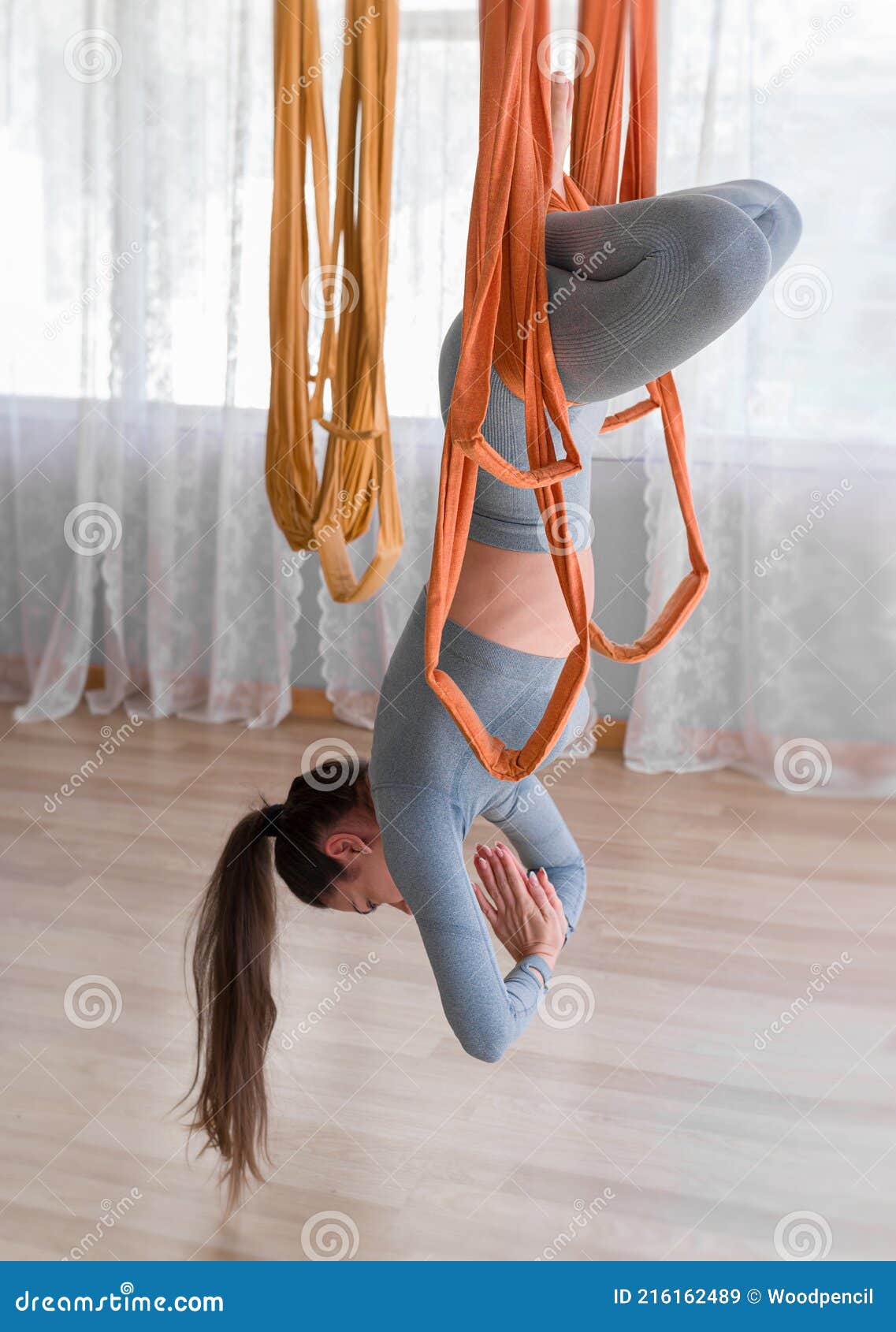 Side View Young Woman Practicing Fly Yoga Hanging Upside Down Stock