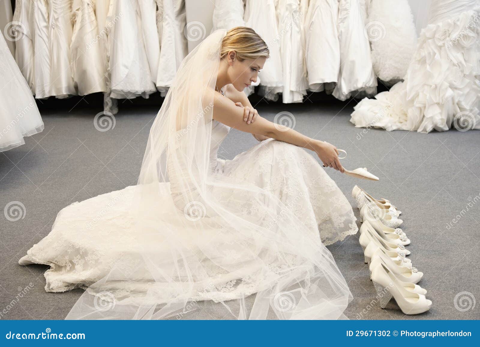 side view of young woman in wedding dress confused while selecting footwear
