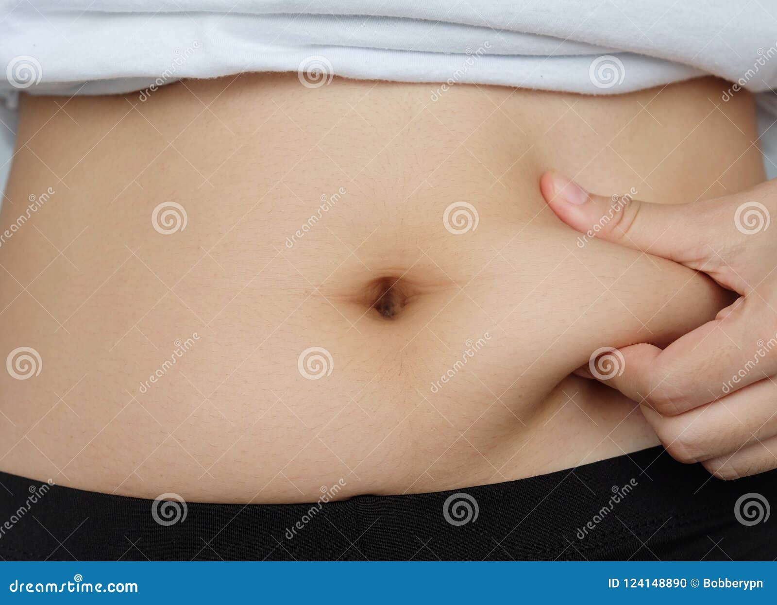 side of woman hand catching fat body belly paunch , diabetic risk factor .