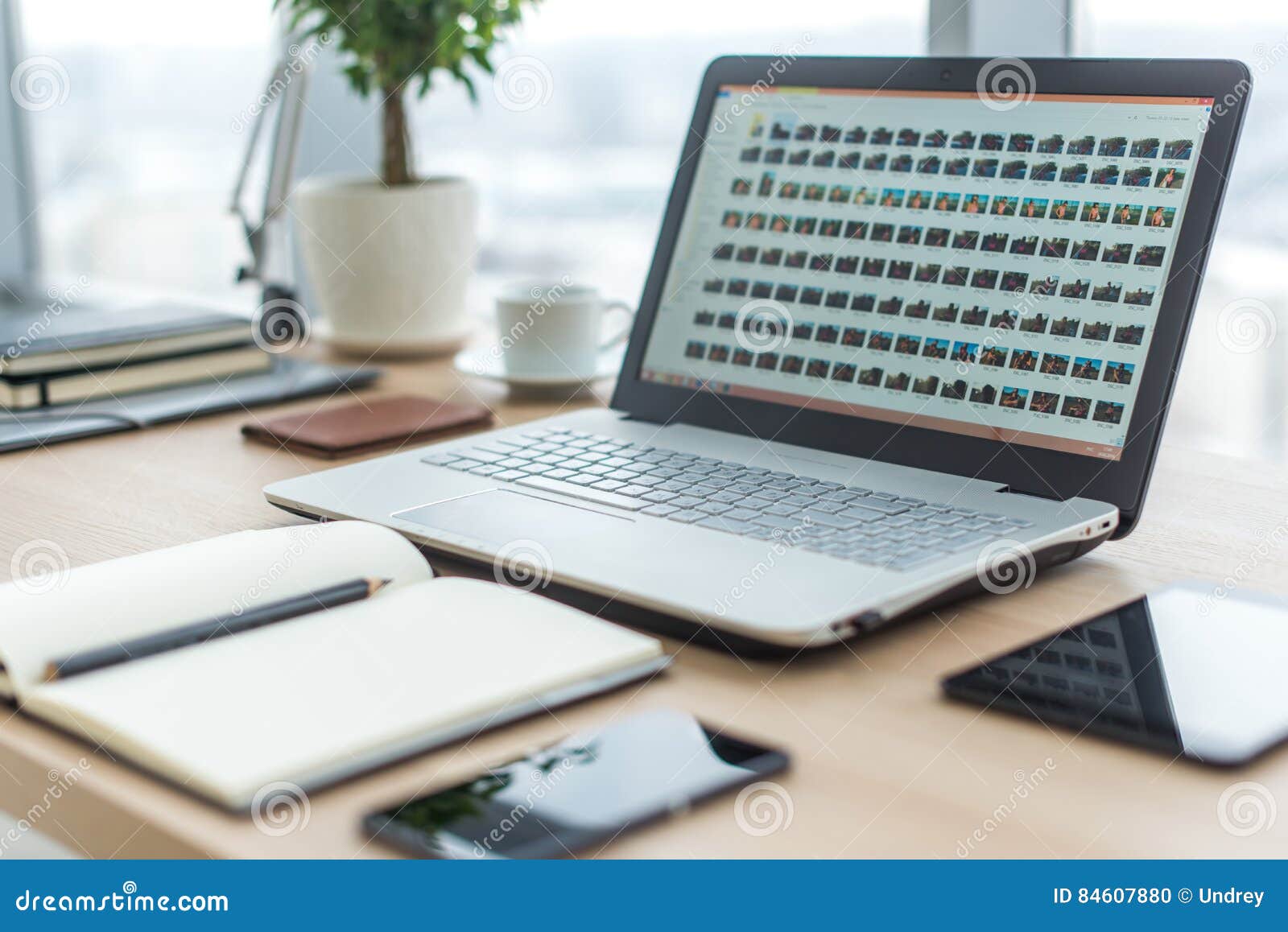 Sideview of Office Desktop with Blank Laptop and Various Tools. Stock