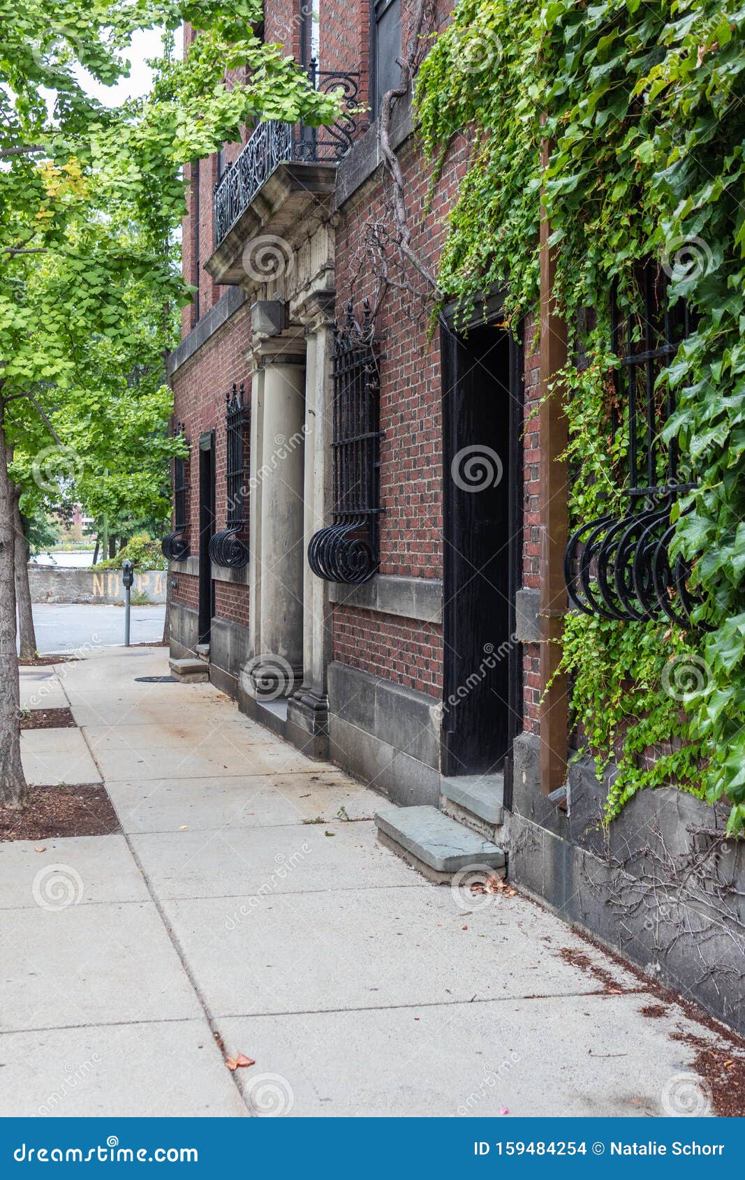 Sidewalk Alongside Residential Building With Bowed Wrought Iron