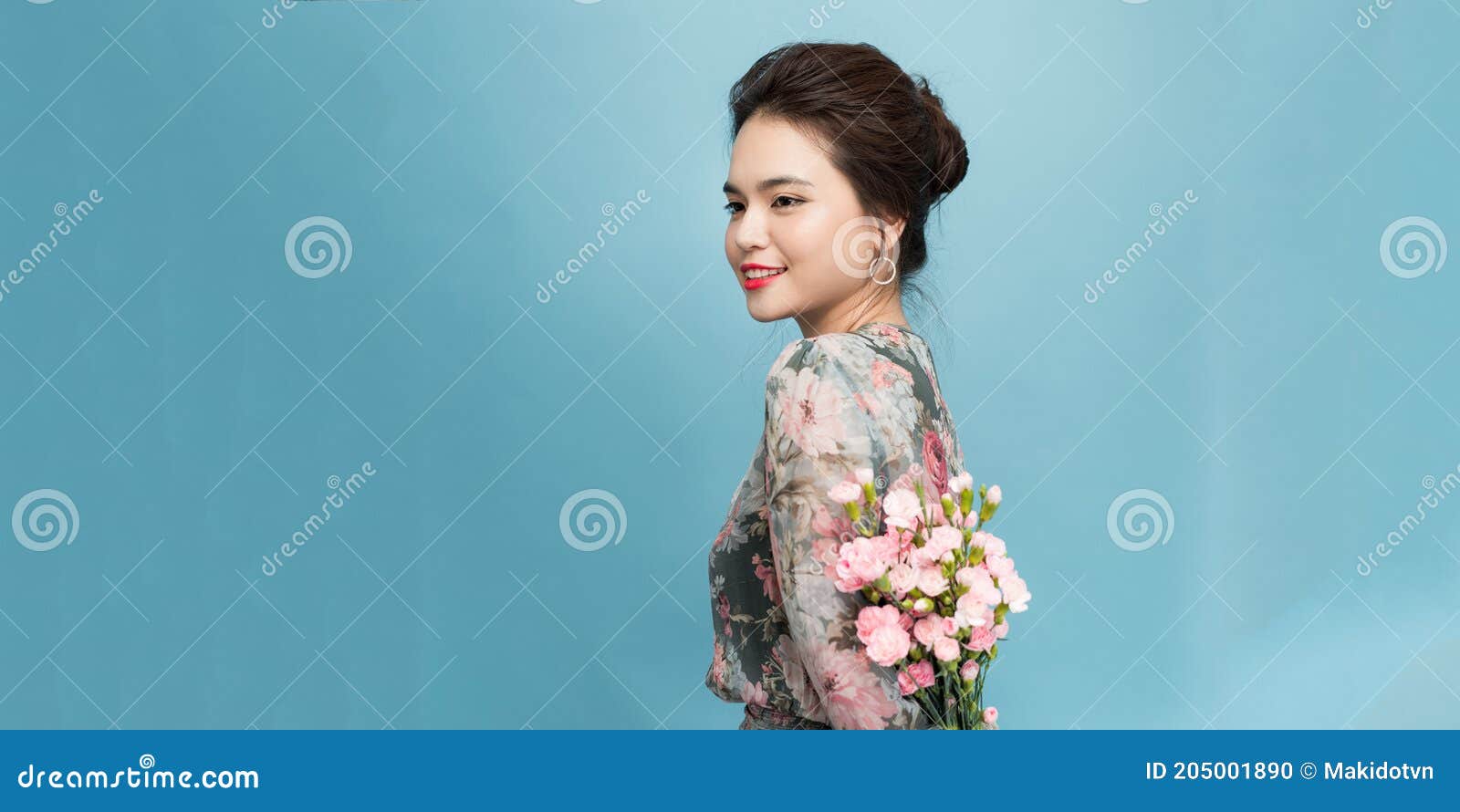 Sideways Shot Of Pleased Attractive Young Woman Holds Spring Flowers