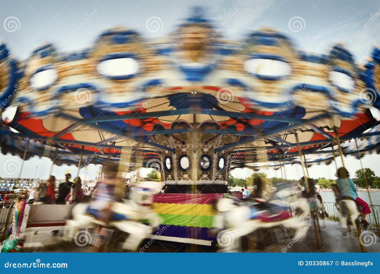 Sie spinnen mich fröhlich gehen Umlauf-rechter Umlauf. Fröhlich gehen Umlauf in der Bewegung mit See und Gebäude im Hintergrund. Alles Personenscheinen werden durch Bewegung oder zu weit im Hintergrund, identifizierbar zu sein verwischt.