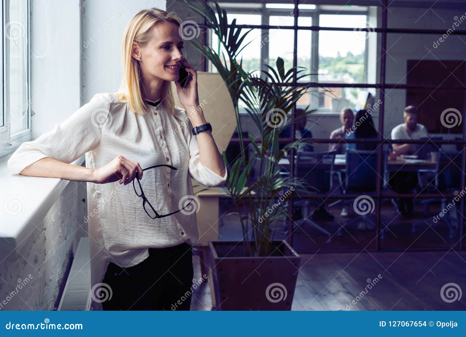 Siempre En Tacto Mujer Joven Confiada En Ropa De Sport Elegante Que Habla  En El Teléfono Móvil Y Que Sonríe Mientras Que Se Coloc Foto de archivo -  Imagen de felicidad, ocasional