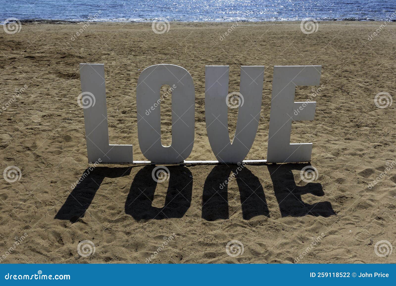 Sign of the Word Love and Its Shadow on a Beach Stock Photo Image of