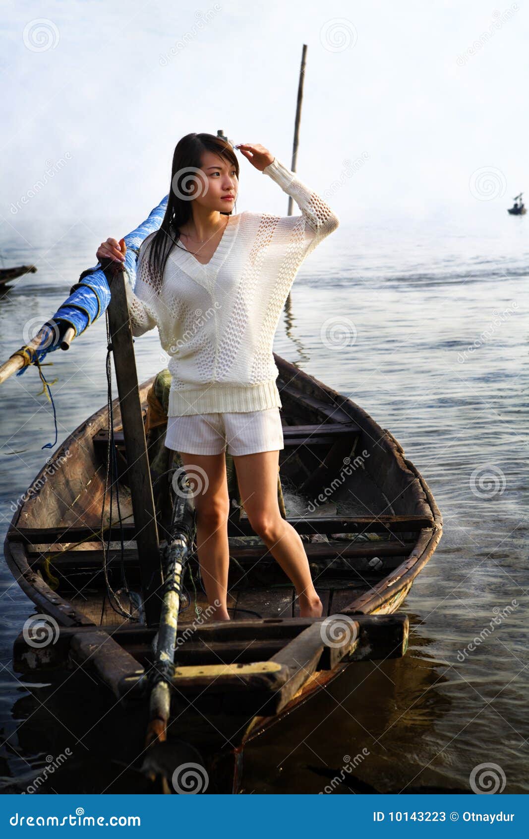 Signora che esamina alba sulla barca tradizionale. La signora che esamina l'alba sulla barca tradizionale del pescatore, la zona era copertura da nebbia/da foschia