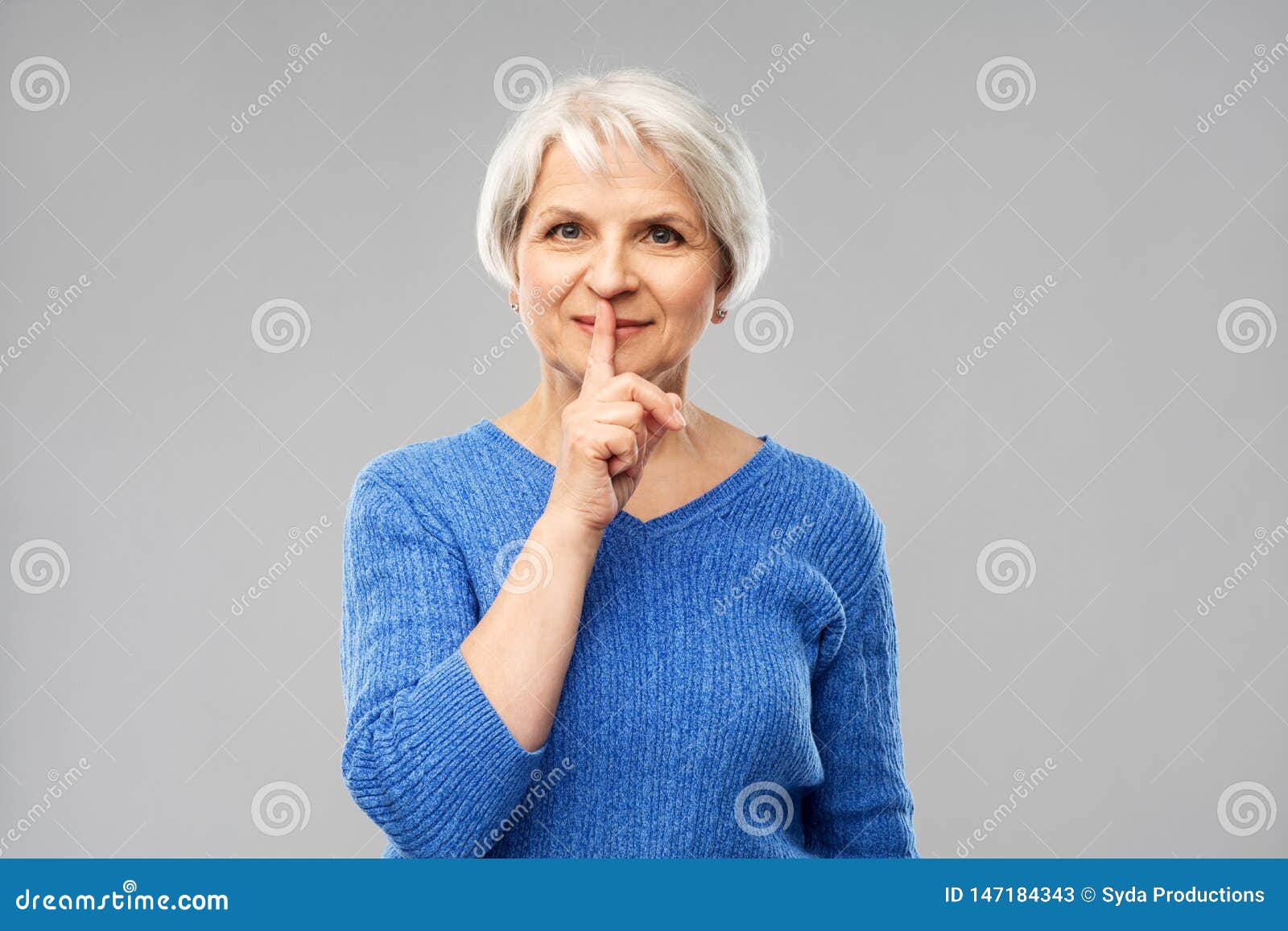 Senior Woman Making Shush Gesture In Kitchen Stock Image 
