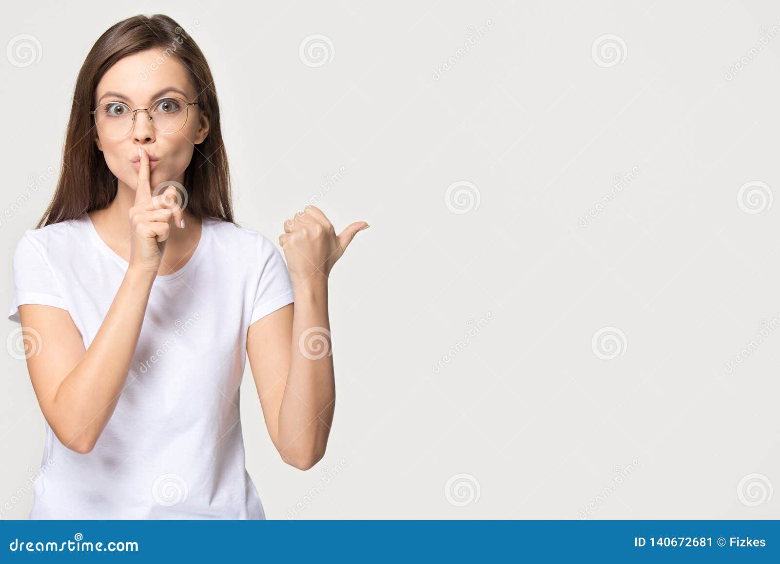 silent girl holding finger on lips  on grey background
