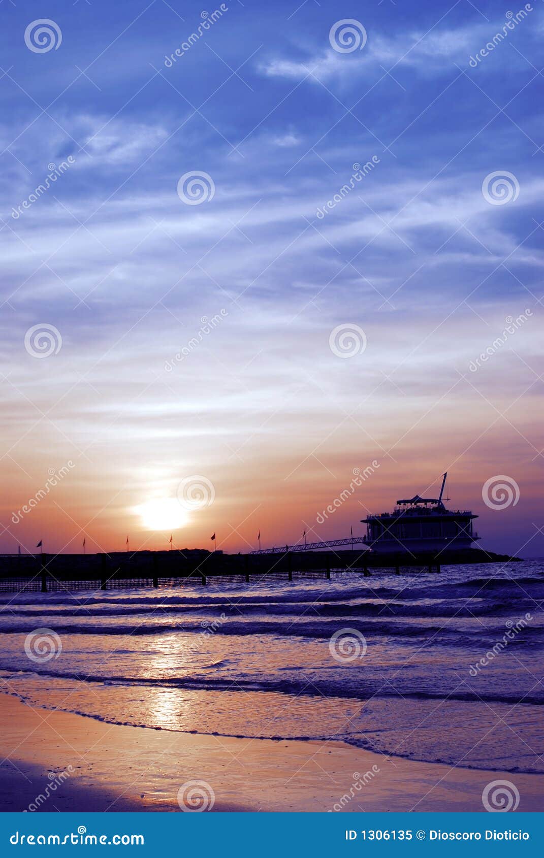 A silhouette shot of a cafe at the beach at sunset